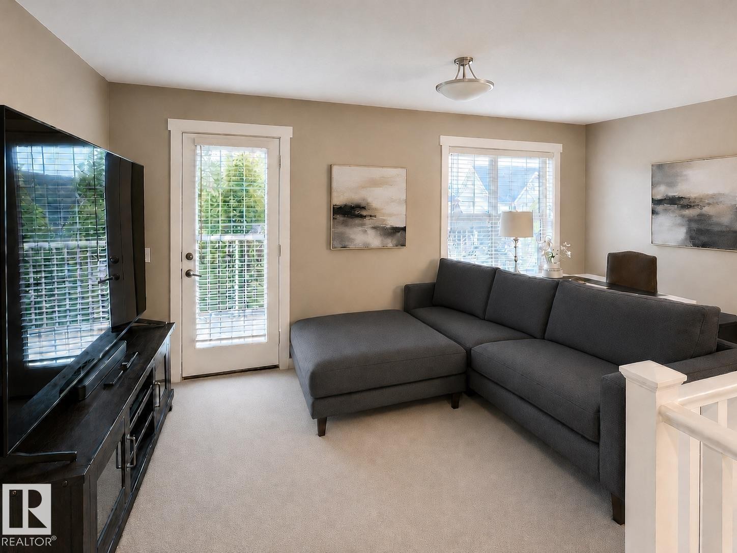 Carpeted living space with a white baluster railing and a glass paneled door - 2337 Frezenberg Avenue Nw, Edmonton, AB - Indoor Photo Showing Living Room