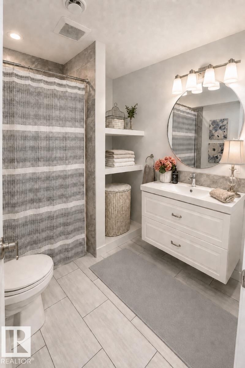 Floating vanity with integrated sink, modern circular mirror, and brushed nickel light fixture - 2337 Frezenberg Avenue Nw, Edmonton, AB - Indoor Photo Showing Bathroom