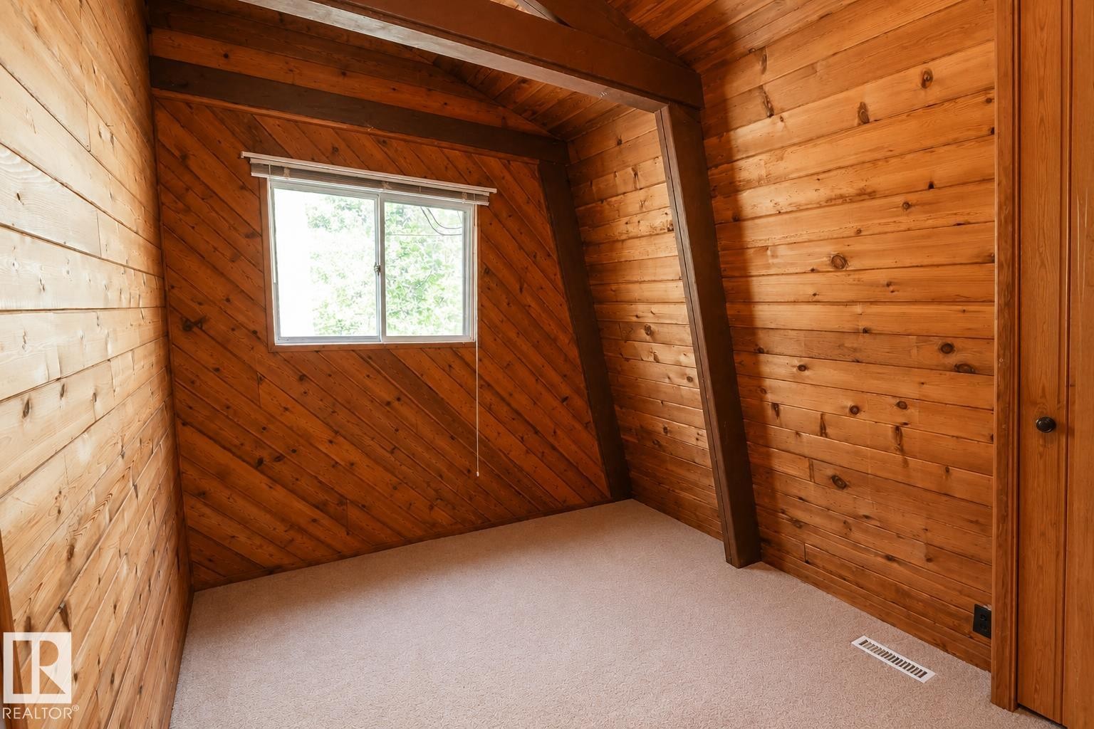 Vaulted ceiling bedroom featuring wood-paneled walls, exposed wood beams, a window, and neutral carpet flooring - 329 60417 Range Road 124, Rural St. Paul County, AB - Indoor Photo Showing Other Room