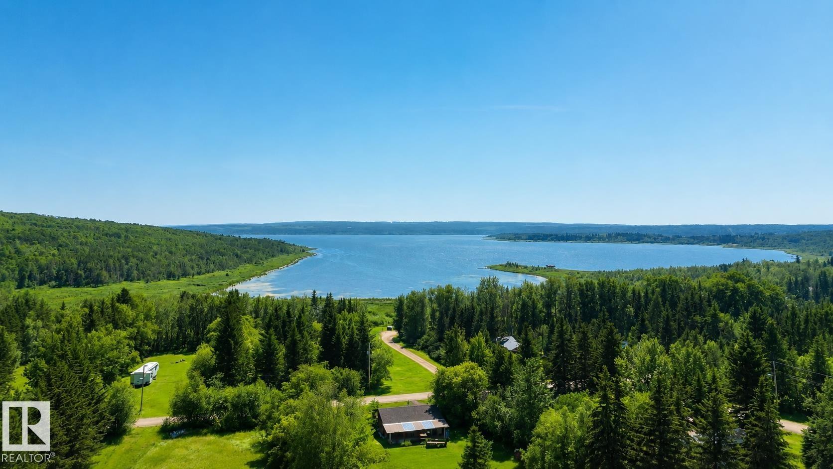 Expansive property featuring a wooded landscape, a large body of water, and a clear blue sky - 329 60417 Range Road 124, Rural St. Paul County, AB - Outdoor With Body Of Water With View