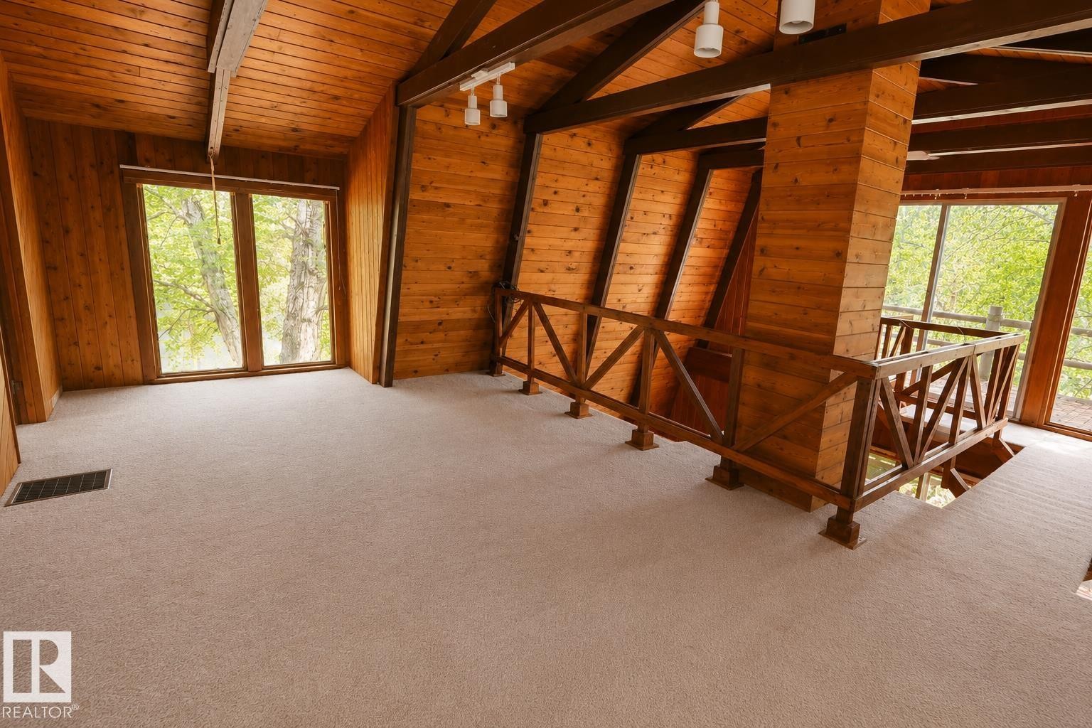 Spacious upper-level room featuring light tan carpeting and expansive windows - 329 60417 Range Road 124, Rural St. Paul County, AB - Indoor Photo Showing Other Room