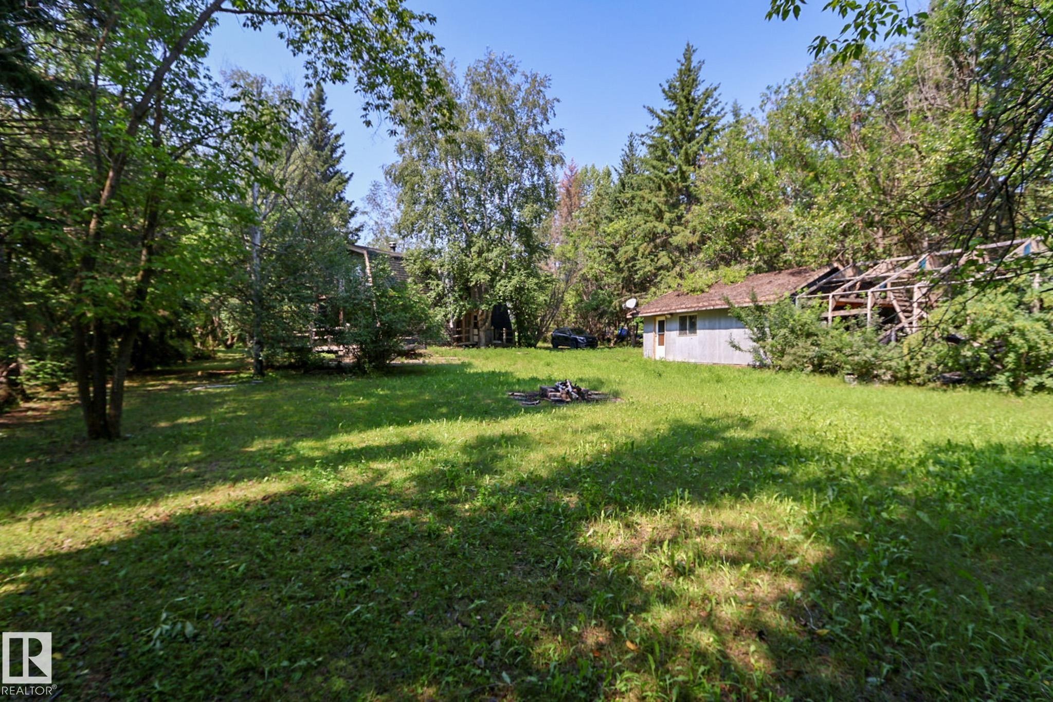 Expansive green space featuring mature trees and a rustic outbuilding - 329 60417 Range Road 124, Rural St. Paul County, AB - Outdoor