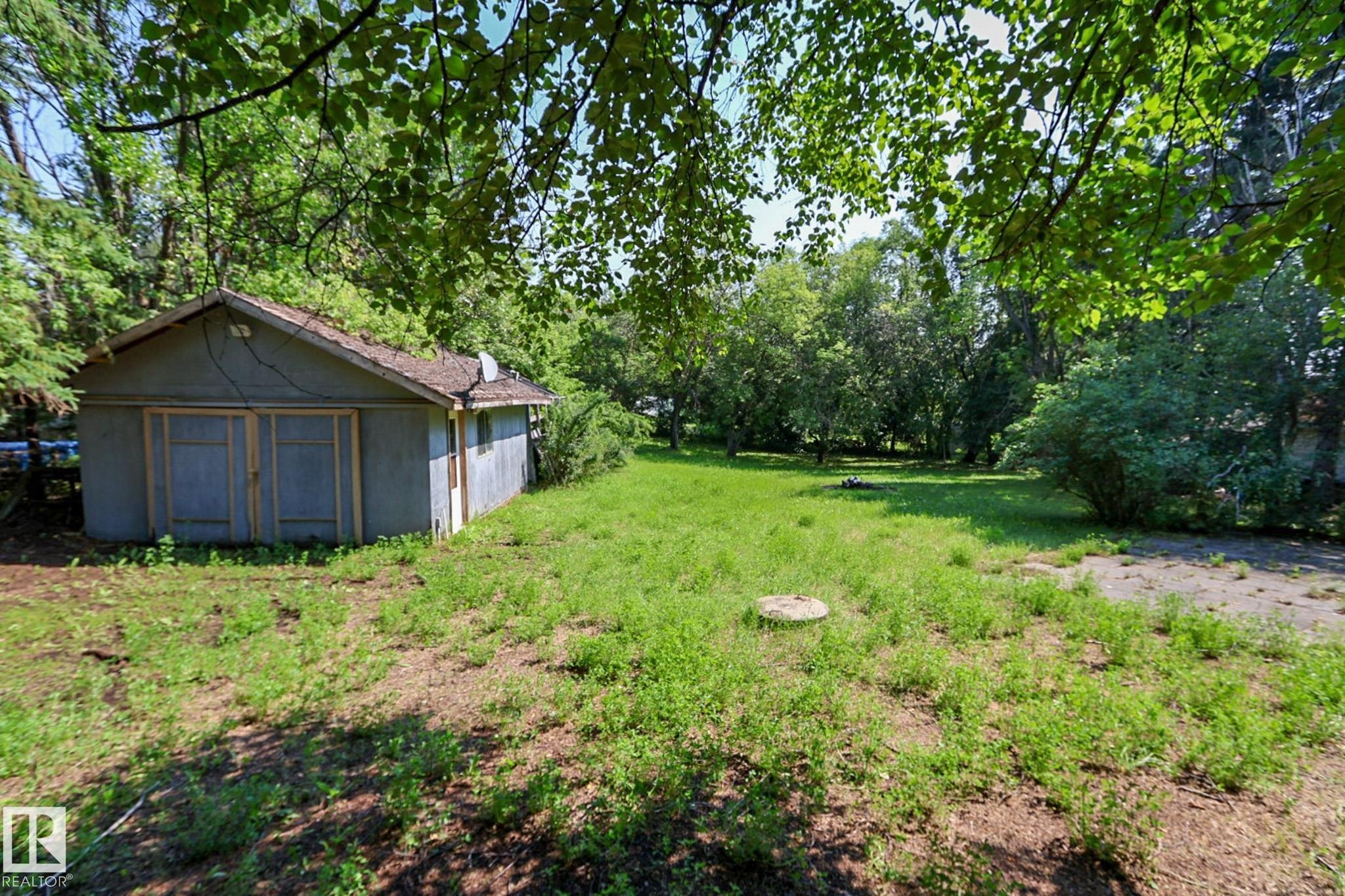 Detached outbuilding with a gabled roof and two wooden access doors - 329 60417 Range Road 124, Rural St. Paul County, AB - Outdoor