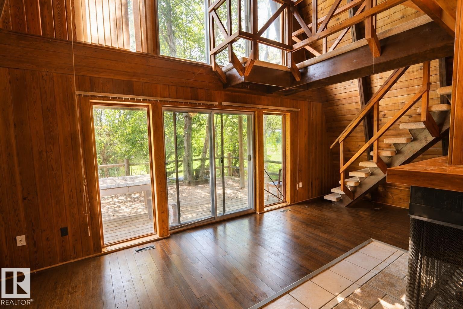 Two-story living area with wood-finish flooring and extensive wood paneling - 329 60417 Range Road 124, Rural St. Paul County, AB - Indoor Photo Showing Other Room