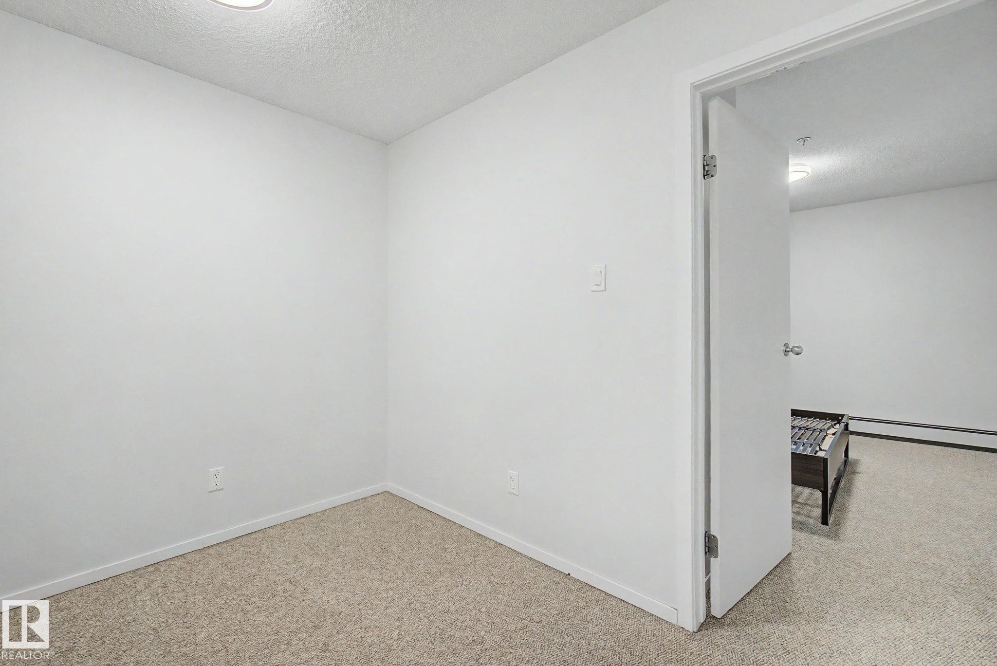Room featuring neutral carpeting, white walls, and a ceiling-mounted light fixture - 11150 83 Avenue Nw, Edmonton, AB