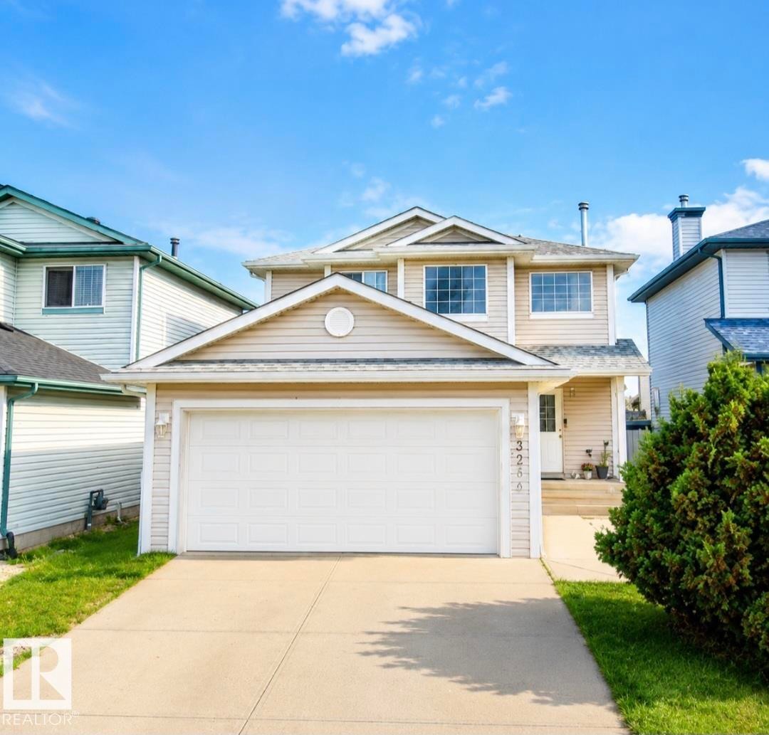 Two-story residence featuring light-toned siding and a prominent two-car garage - 3236 27 Avenue Nw, Edmonton, AB - Outdoor