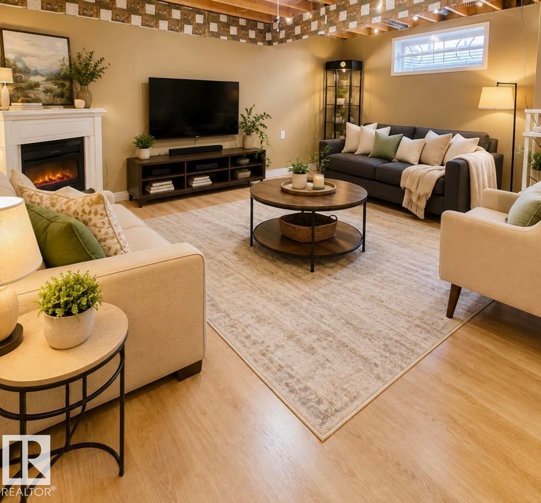 Living area featuring light wood-finish flooring, an exposed ceiling with recessed lighting, a white mantel, and an egress window - 3236 27 Avenue Nw, Edmonton, AB - Indoor With Fireplace