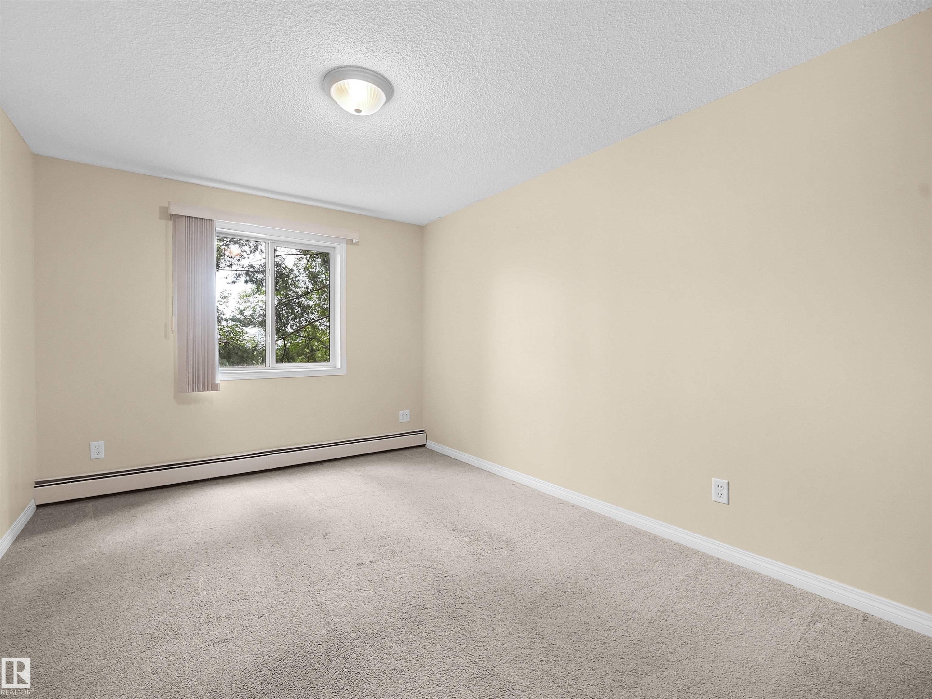 Room featuring neutral-toned walls, light-colored carpeting, and a white trim baseboard - #220 245 Edwards Dr Sw, Edmonton, AB - Indoor Photo Showing Other Room