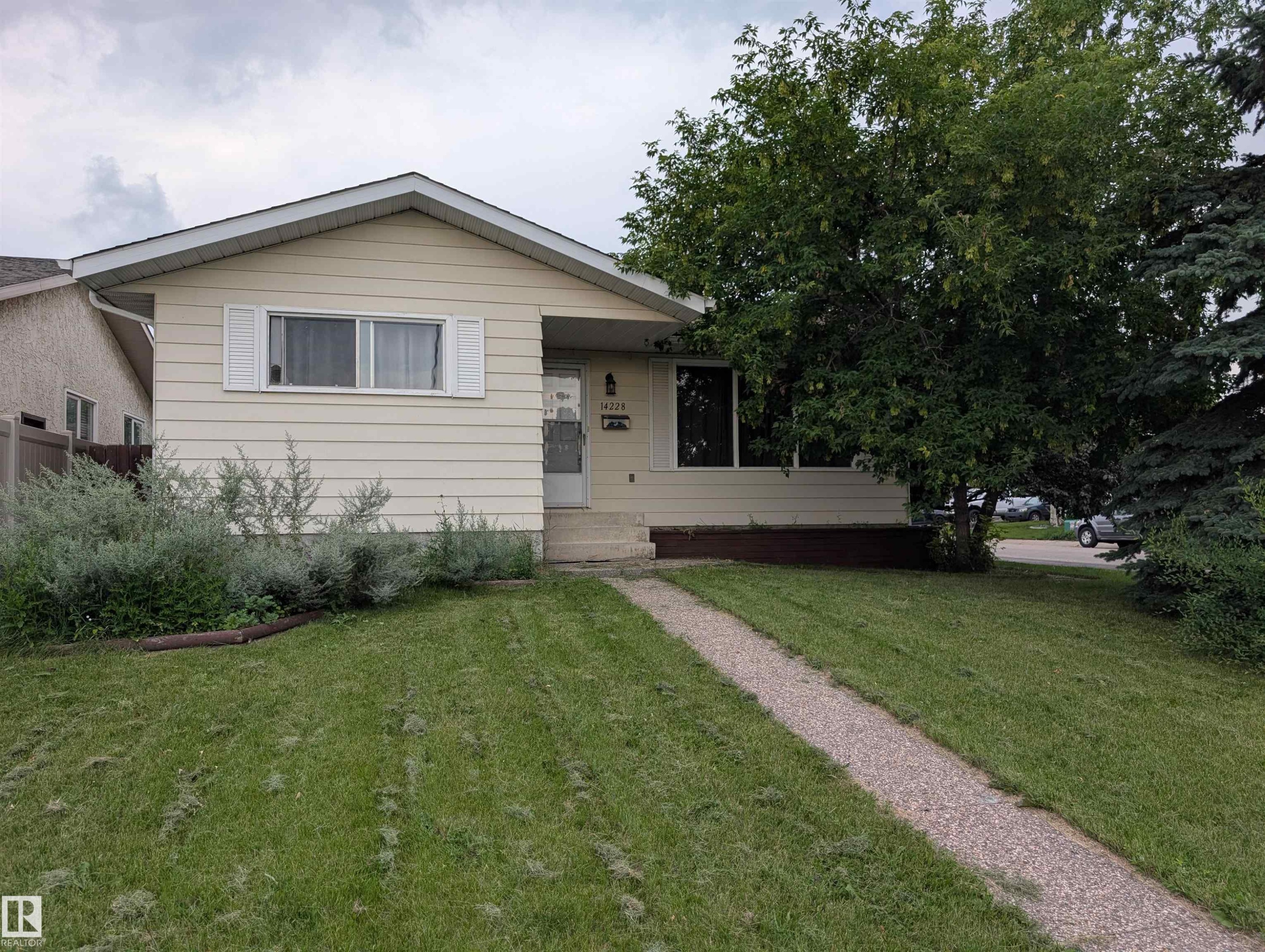 Ranch-style exterior with beige siding, a gabled roof, and white window shutters - 14228 22 Street Nw, Edmonton, AB - Outdoor