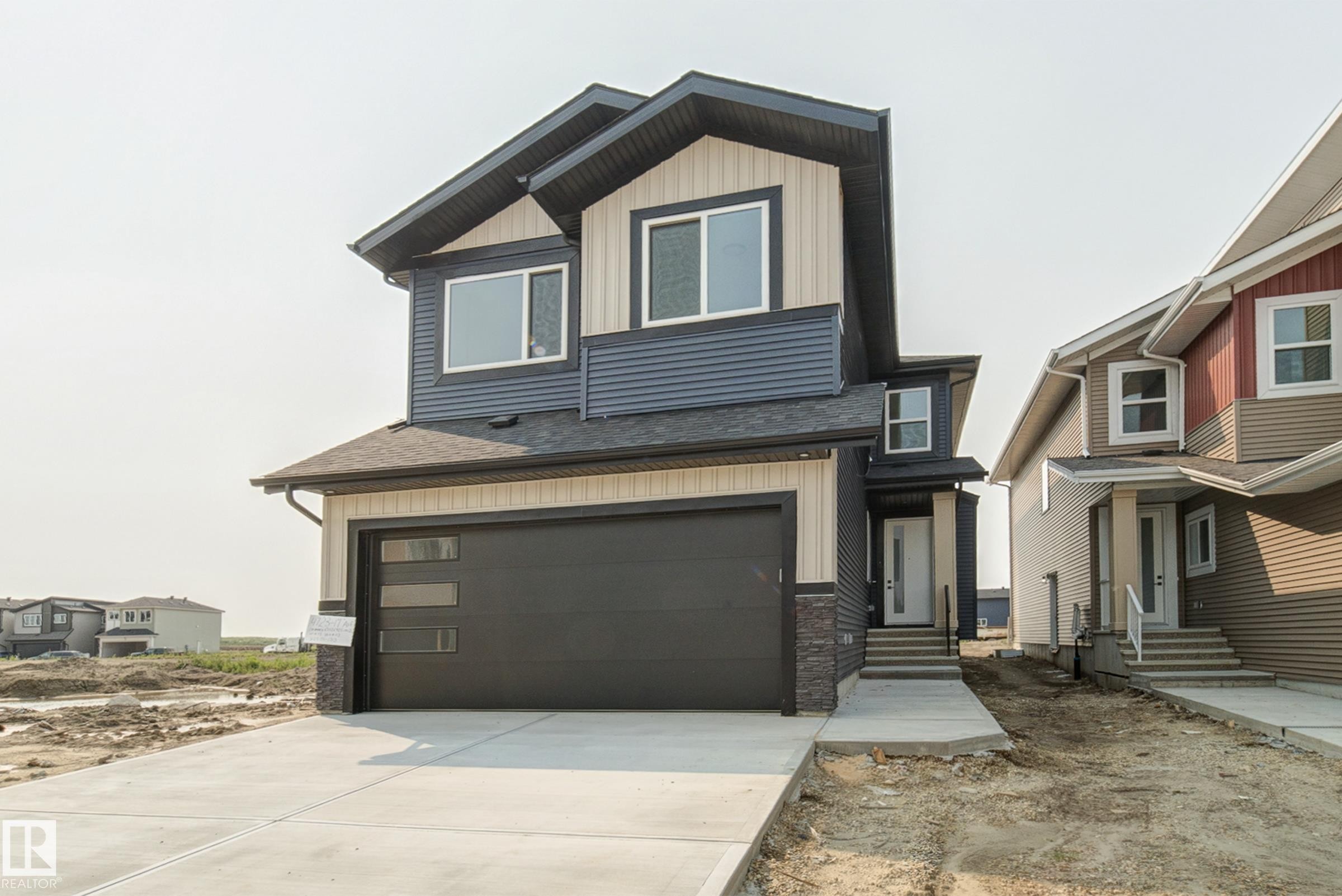 Contemporary two-story residence featuring a two-tone exterior with dark blue horizontal siding and light beige vertical siding - 4723 17 Avenue Sw, Edmonton, AB - Outdoor With Facade