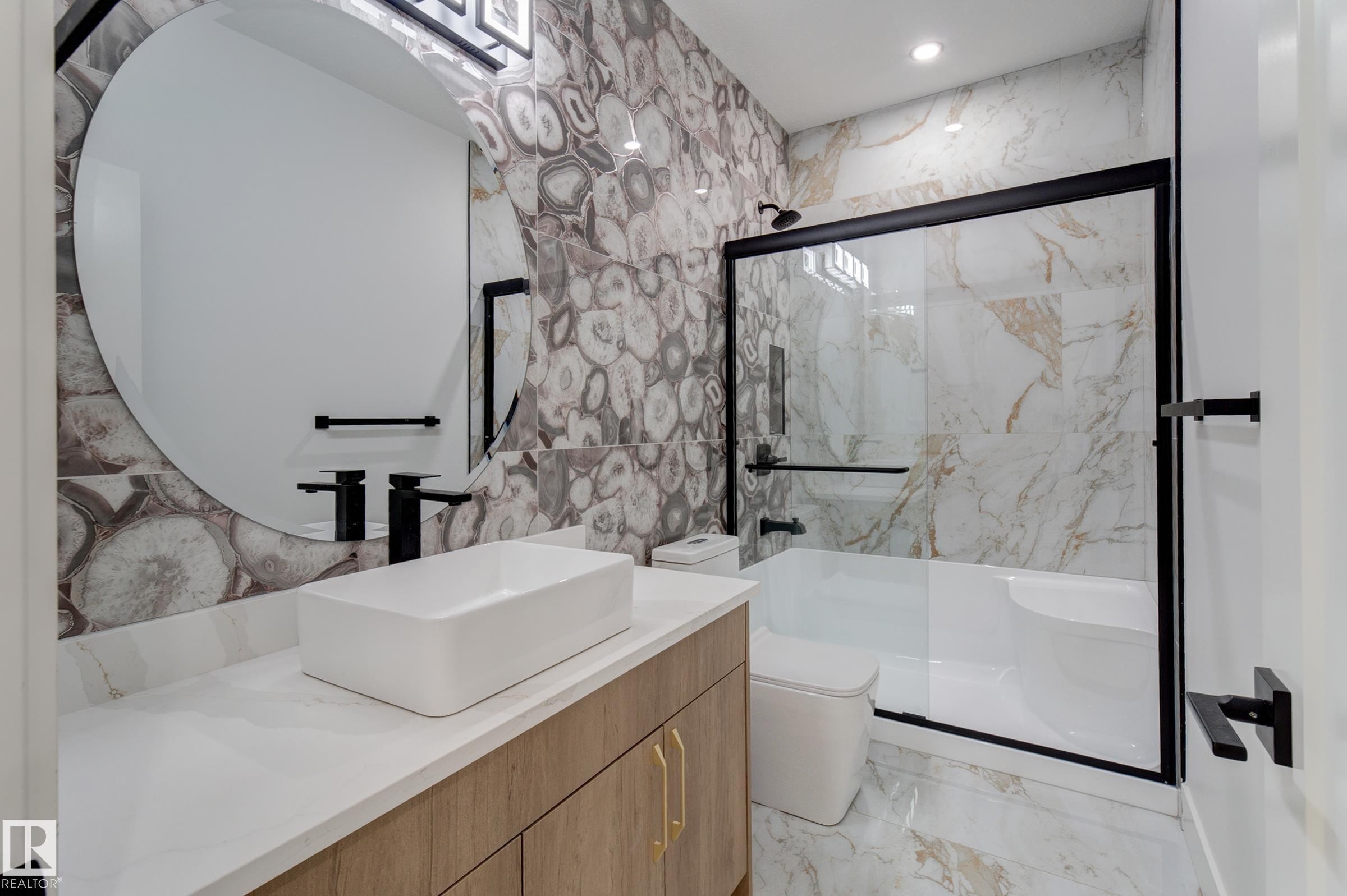 Contemporary bathroom featuring a vessel sink, a large circular mirror, and a wood-finish vanity - 4723 17 Avenue Sw, Edmonton, AB - Indoor Photo Showing Bathroom