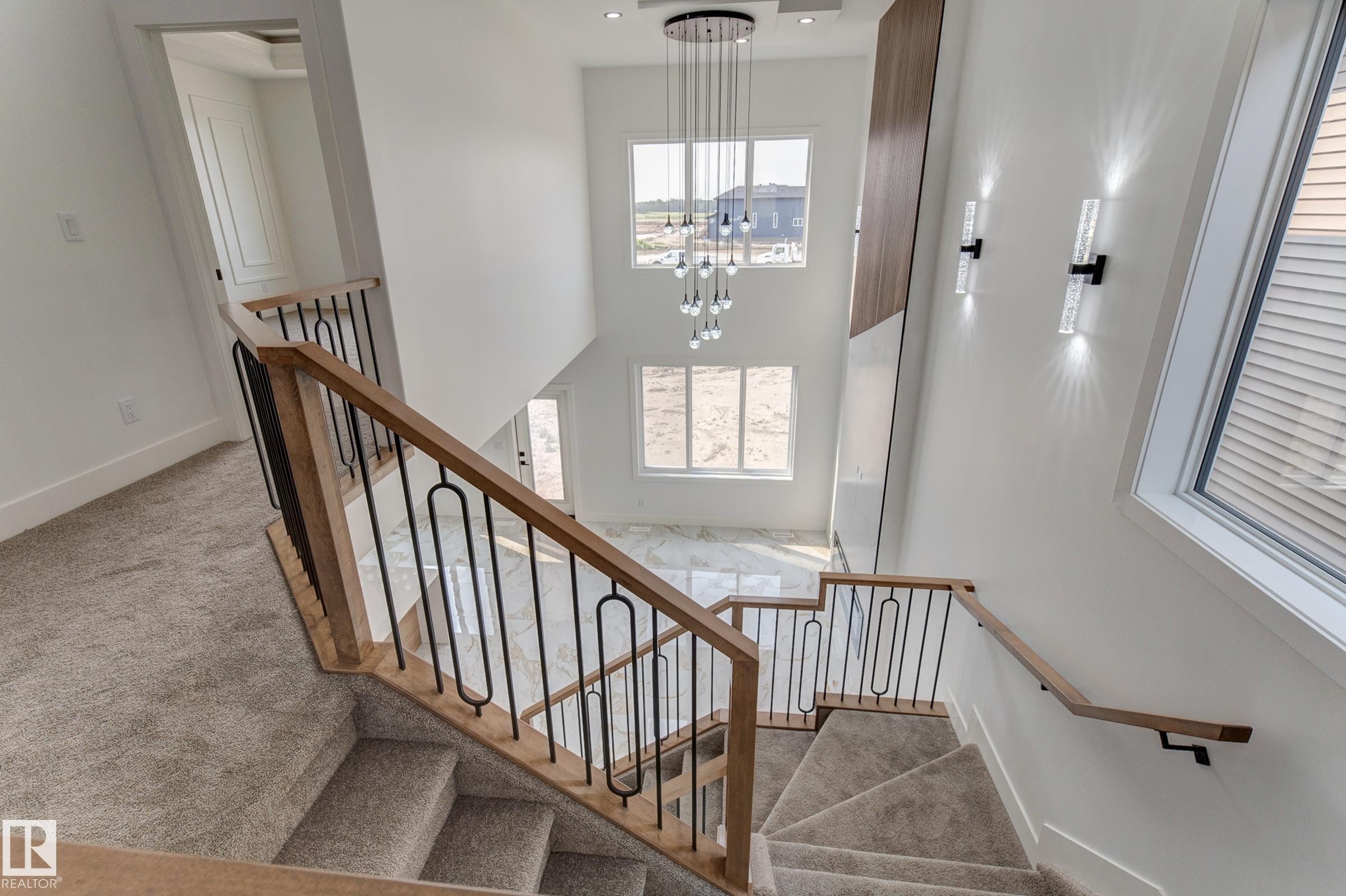 Multi-level staircase with light wood-finish handrails and black metal balusters - 4723 17 Avenue Sw, Edmonton, AB - Indoor Photo Showing Other Room