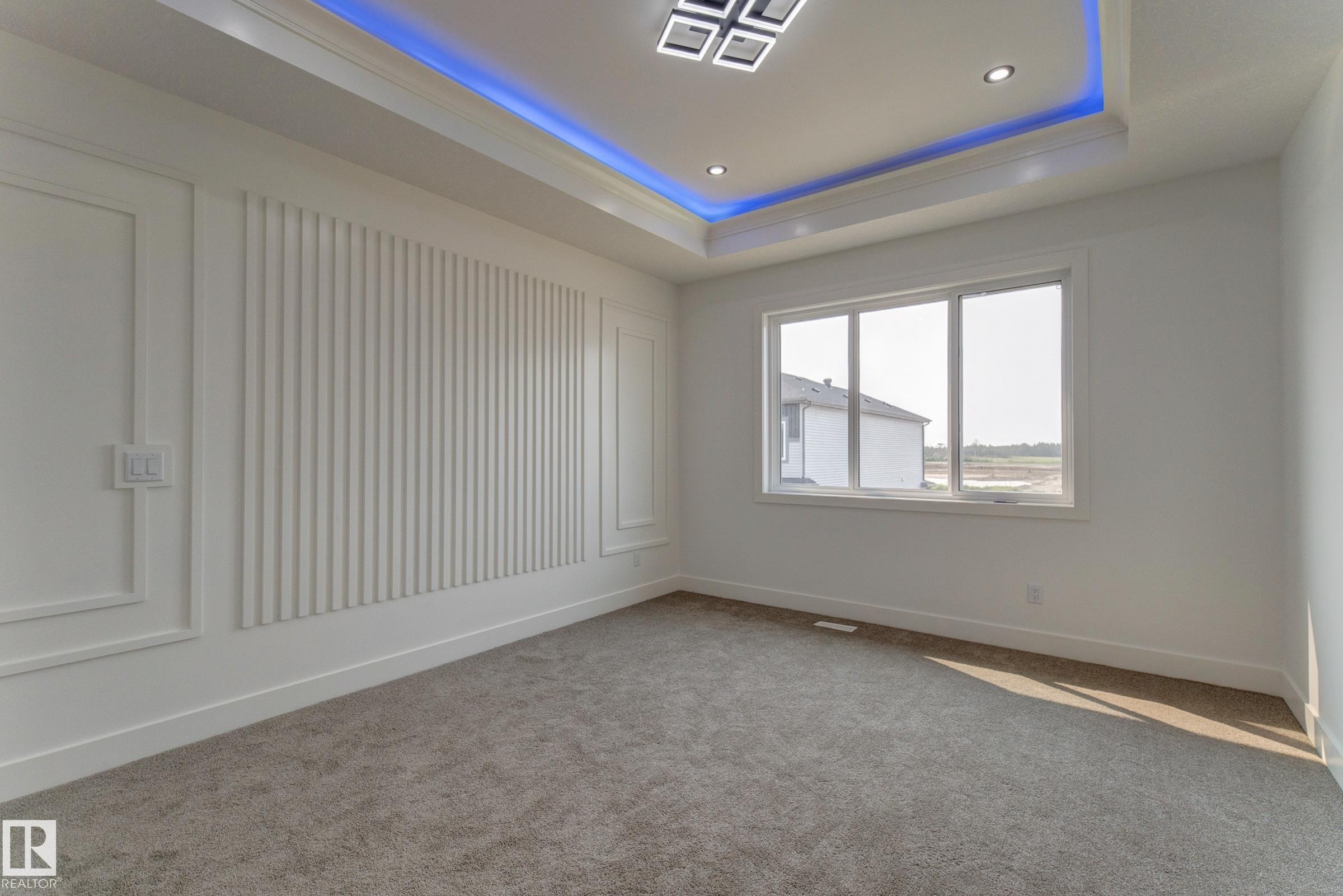 Recessed lighting and a multi-pane window illuminate this space featuring a decorative accent wall with vertical paneling and trim work - 4723 17 Avenue Sw, Edmonton, AB - Indoor Photo Showing Other Room
