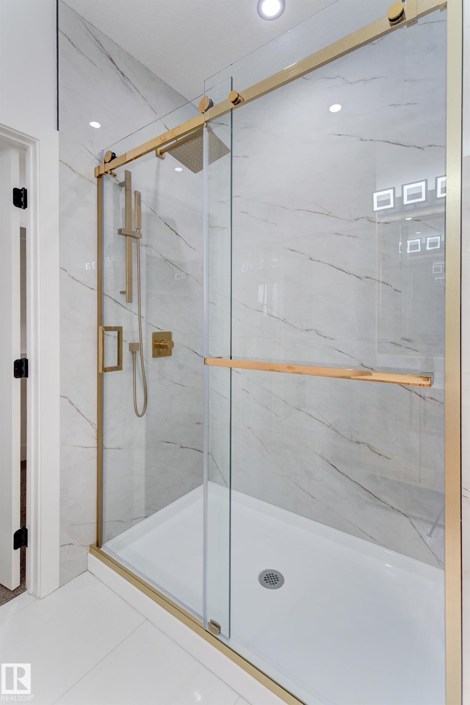 Modern shower enclosure with gold-finish hardware, clear glass sliding door, and a rain showerhead - 4723 17 Avenue Sw, Edmonton, AB - Indoor Photo Showing Bathroom