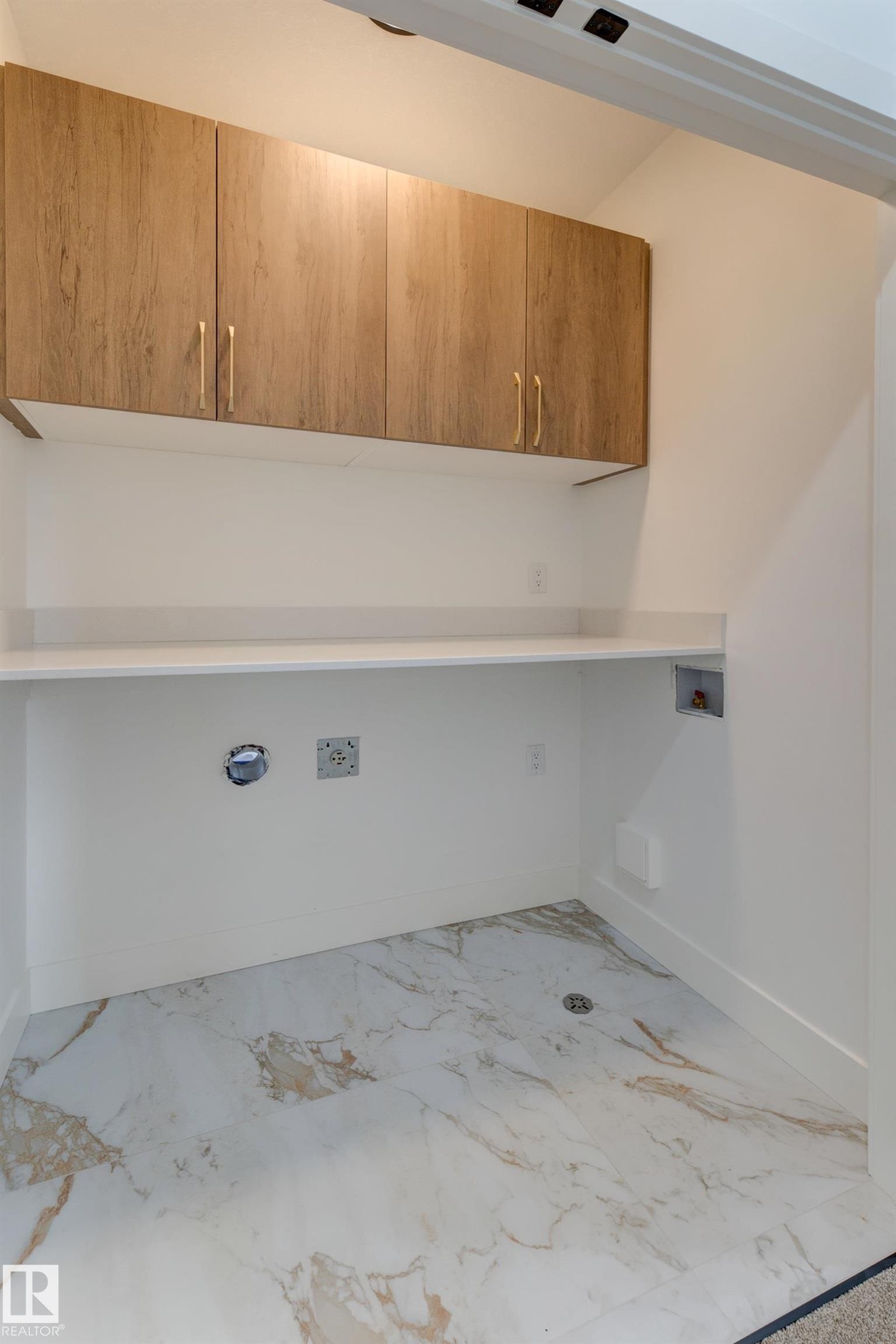 White and gold vein tile flooring complements a white countertop and light wood-finish cabinetry - 4723 17 Avenue Sw, Edmonton, AB - Indoor