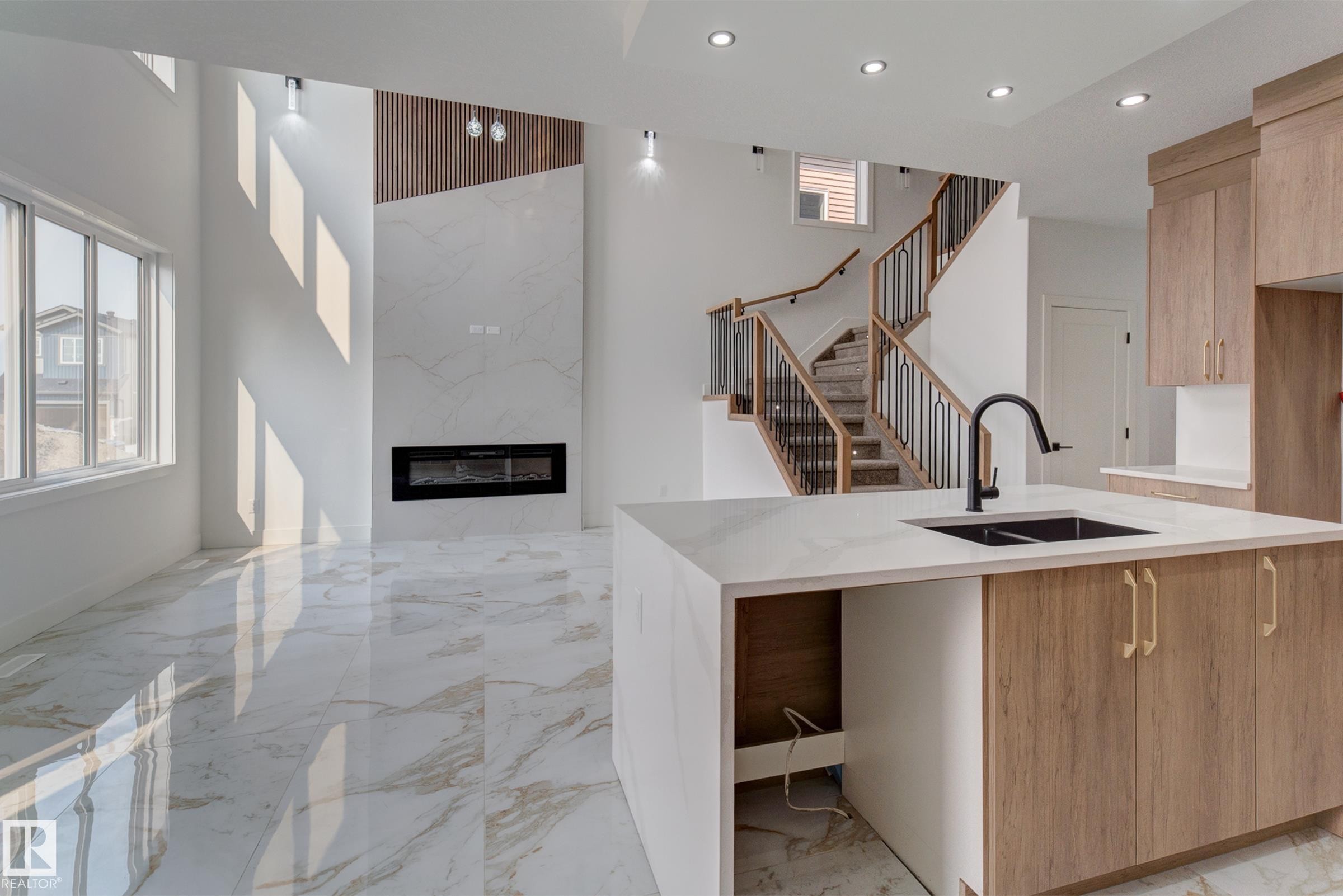 Open concept interior featuring high ceilings, large windows, and large format marble-look tile flooring - 4723 17 Avenue Sw, Edmonton, AB - Indoor Photo Showing Kitchen With Double Sink