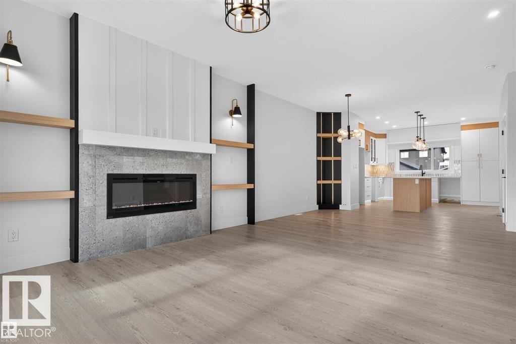 Open-concept living space featuring light wood-finish flooring - 43 River Birch Way, St. Albert, AB - Indoor Photo Showing Living Room With Fireplace