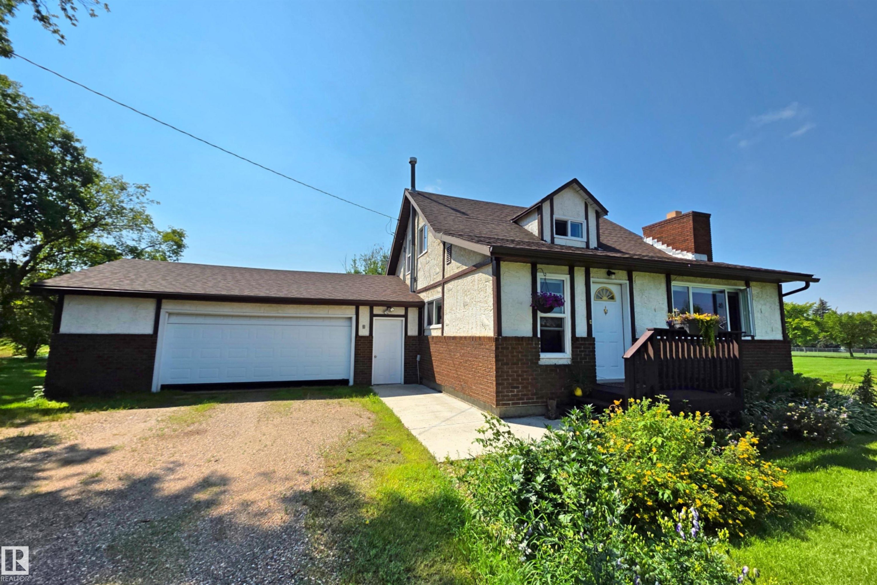 Charming exterior with brick and stucco siding, featuring a prominent dormer window - 3003 Park Avenue, Mallaig, AB - Outdoor