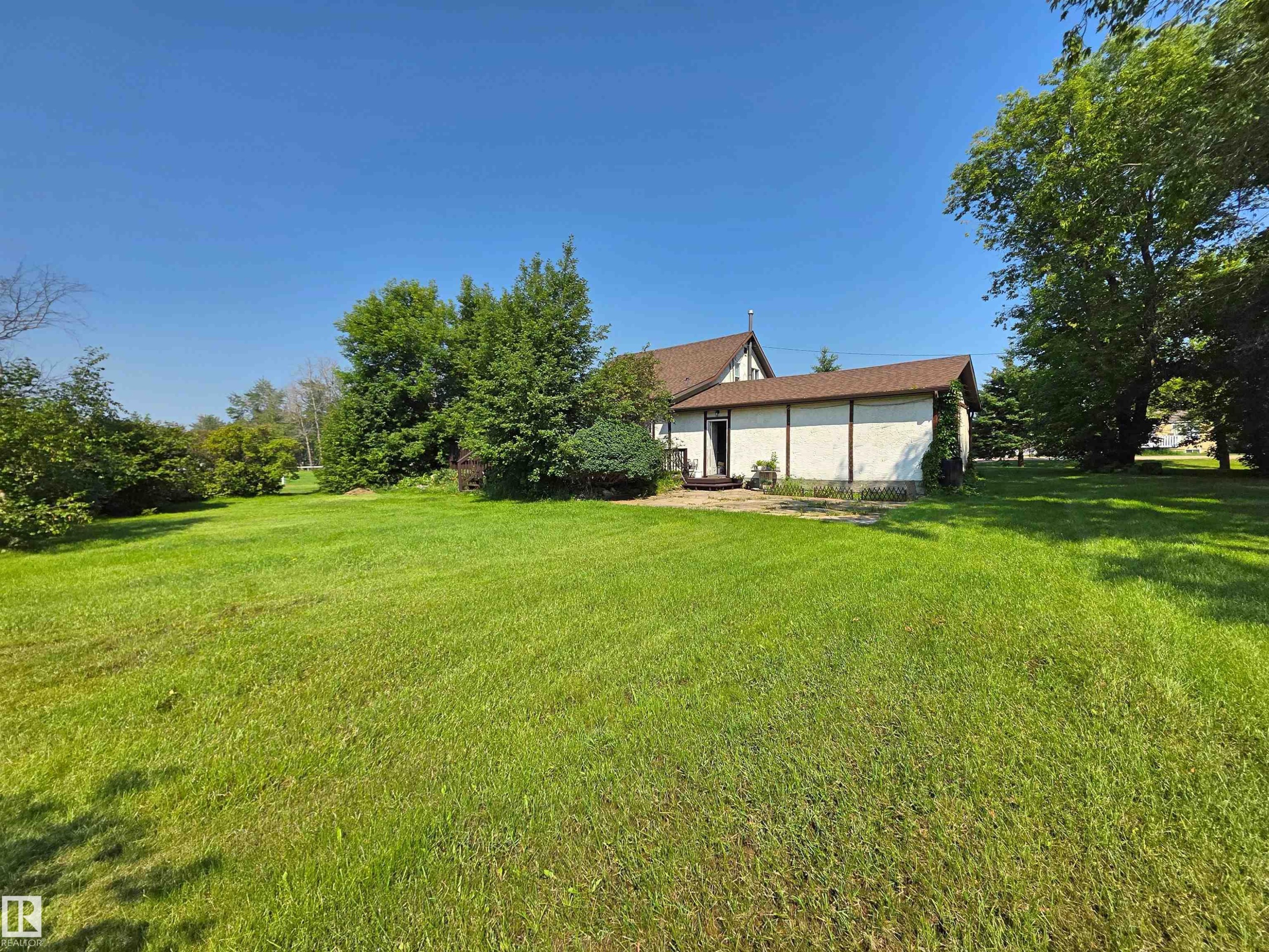Expansive green lawn with mature trees - 3003 Park Avenue, Mallaig, AB - Outdoor