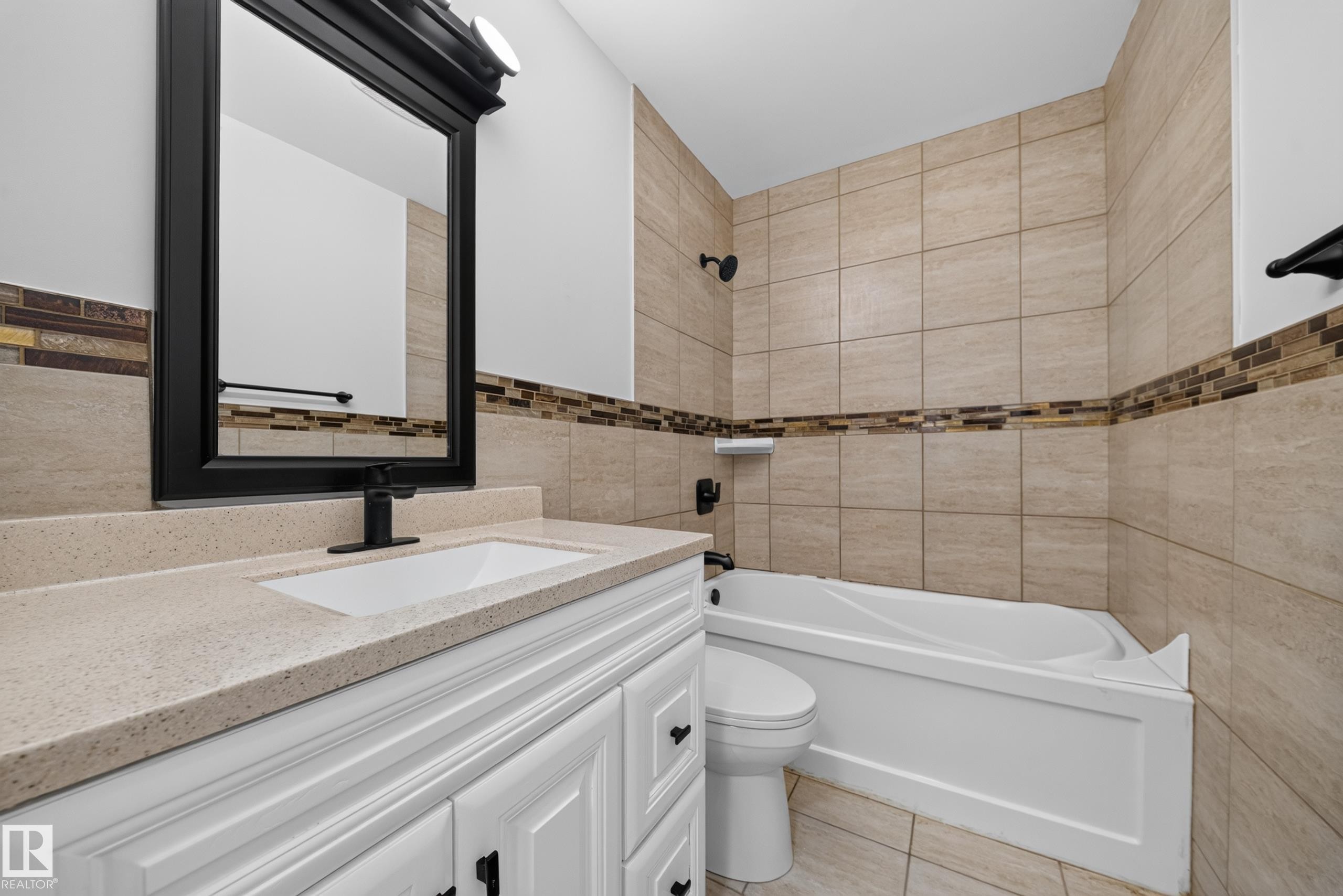 Bathroom featuring a white vanity with a light-toned countertop, an integrated sink, and black fixtures - 5204 97A Avenue Nw, Edmonton, AB - Indoor Photo Showing Bathroom