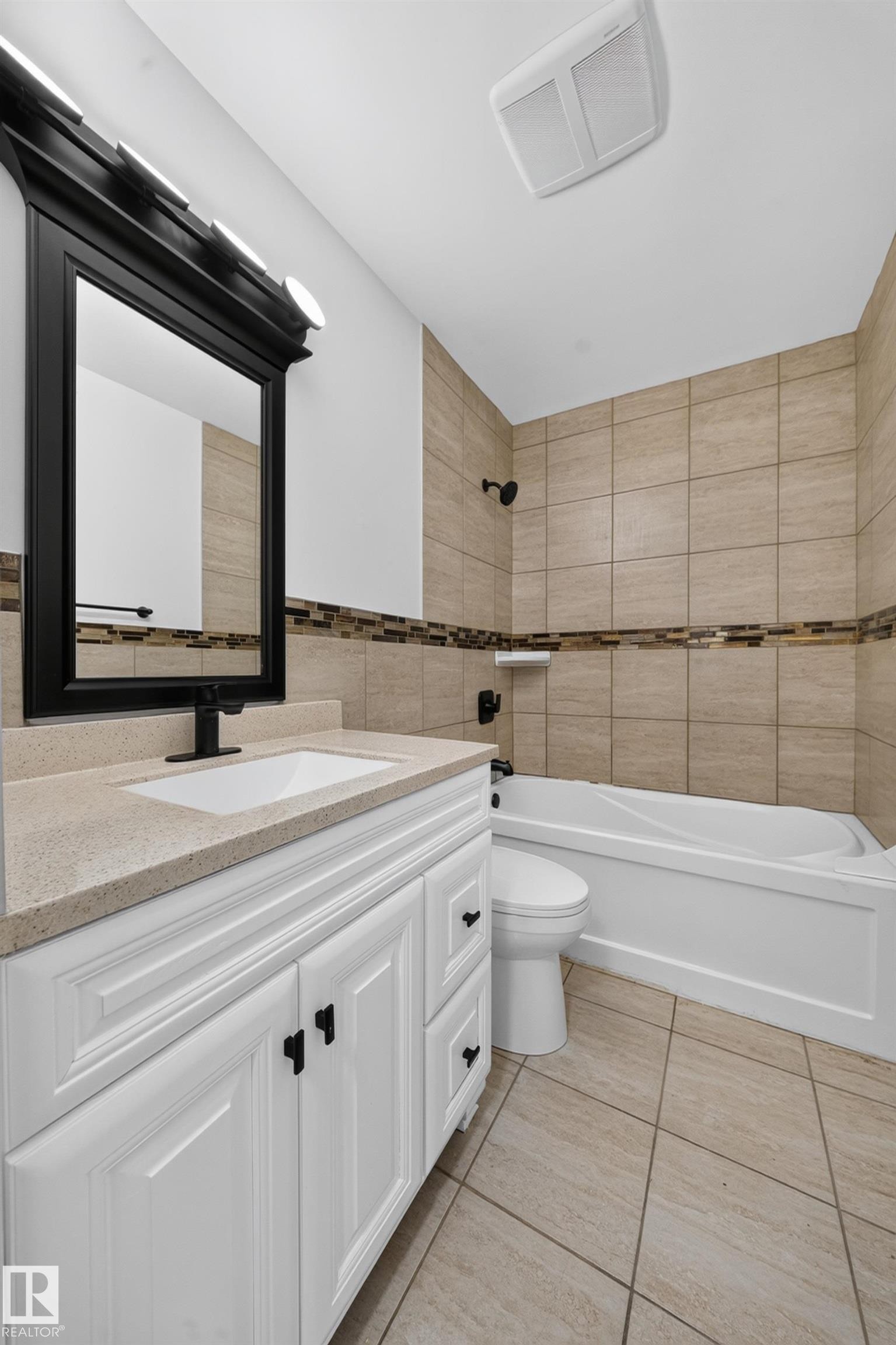 Bathroom featuring a white vanity with a light-colored countertop, an undermount sink, and matte black fixtures - 5204 97A Avenue Nw, Edmonton, AB - Indoor Photo Showing Bathroom