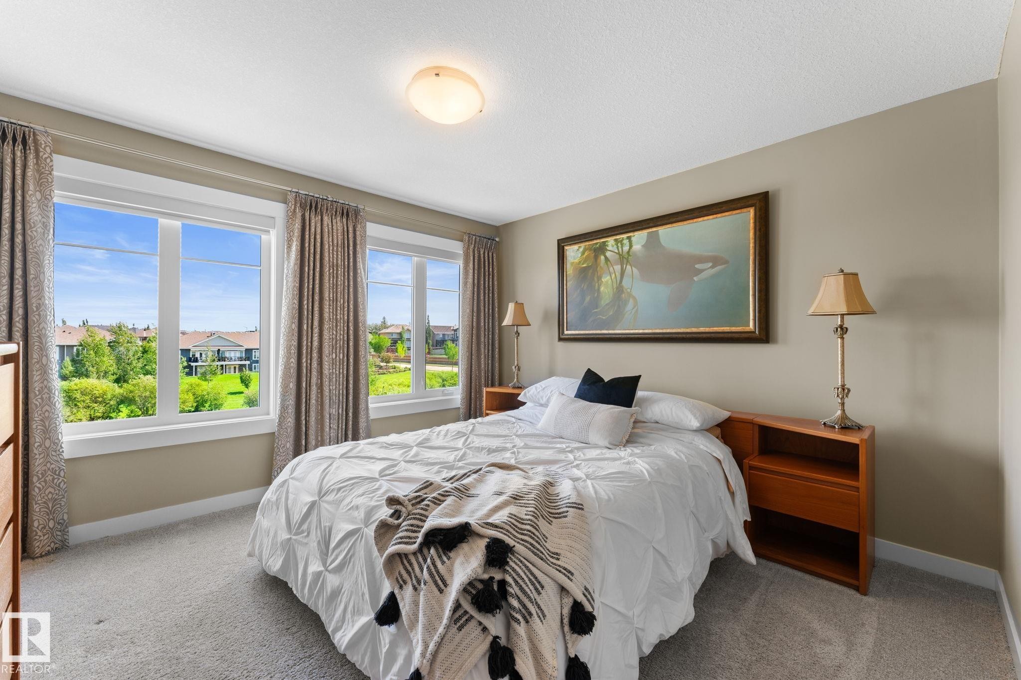 Bright room featuring two large windows with substantial natural light, neutral wall paint, and gray carpet flooring - 3413 Cameron Heights Cove Nw, Edmonton, AB - Indoor Photo Showing Bedroom