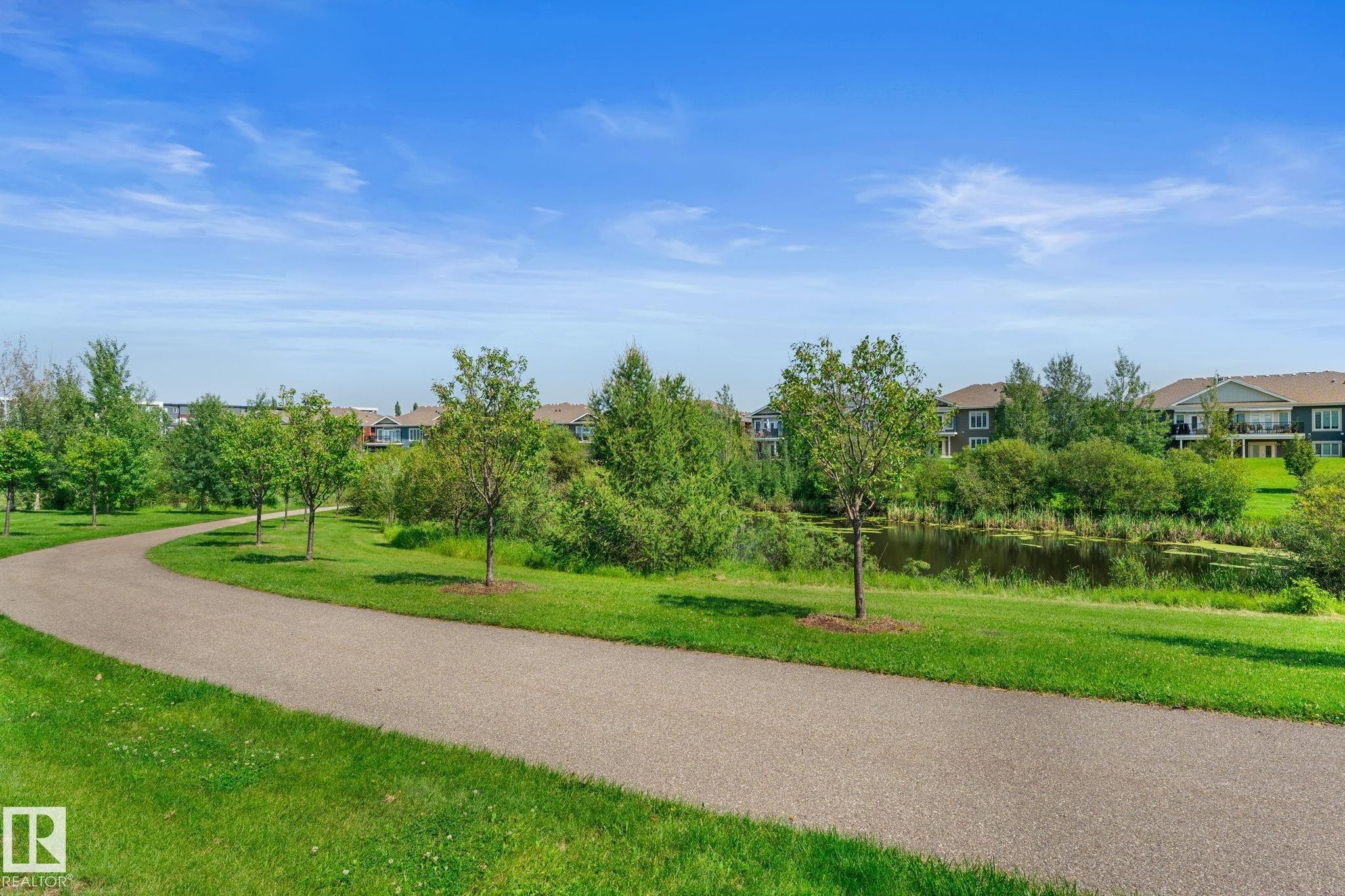 Paved pathway bordered by manicured lawns and young trees - 3413 Cameron Heights Cove Nw, Edmonton, AB - Outdoor With View