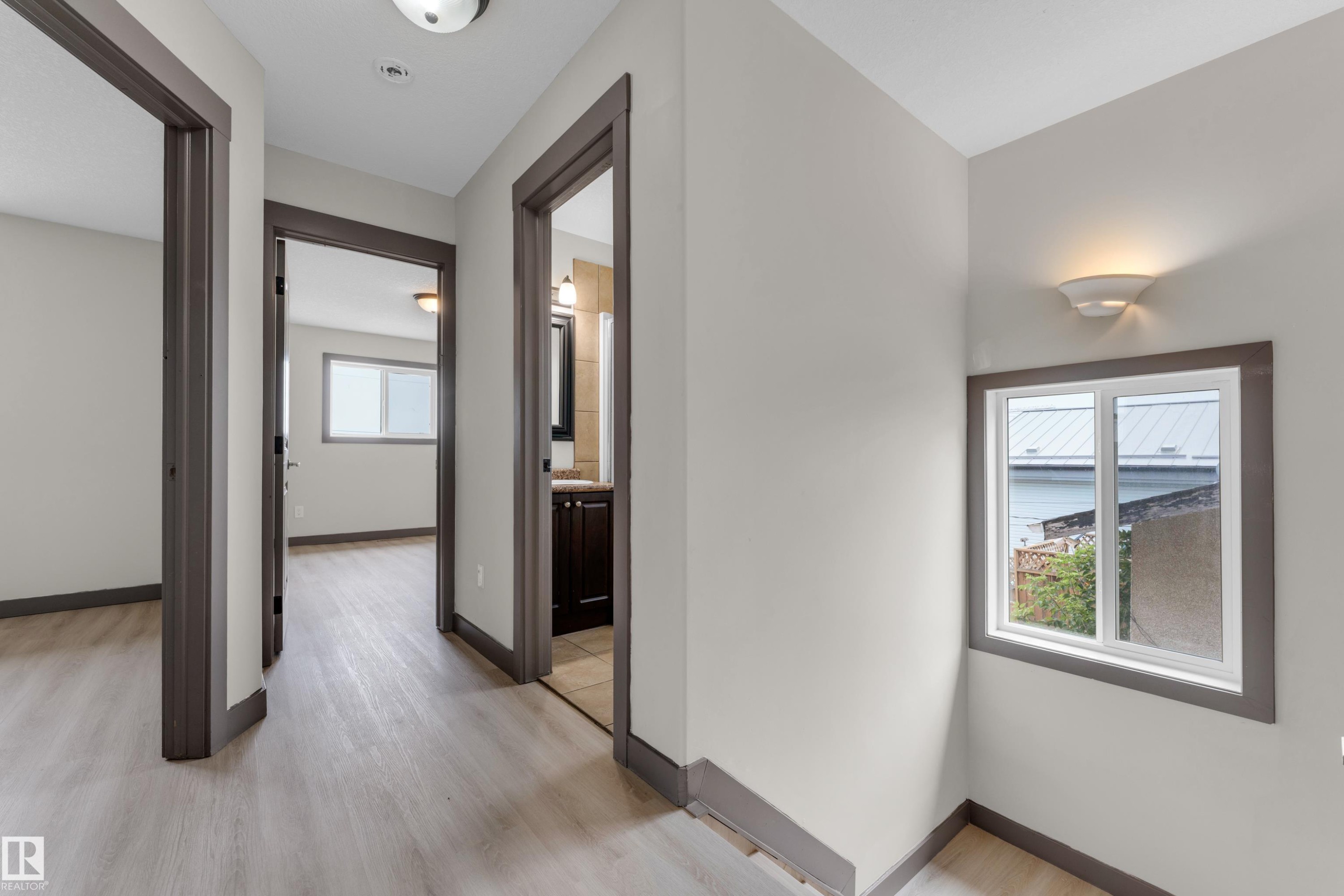 Hallway with wood-finish flooring, white walls, and dark trim - 11817 37 Street Nw, Edmonton, AB - Indoor Photo Showing Other Room