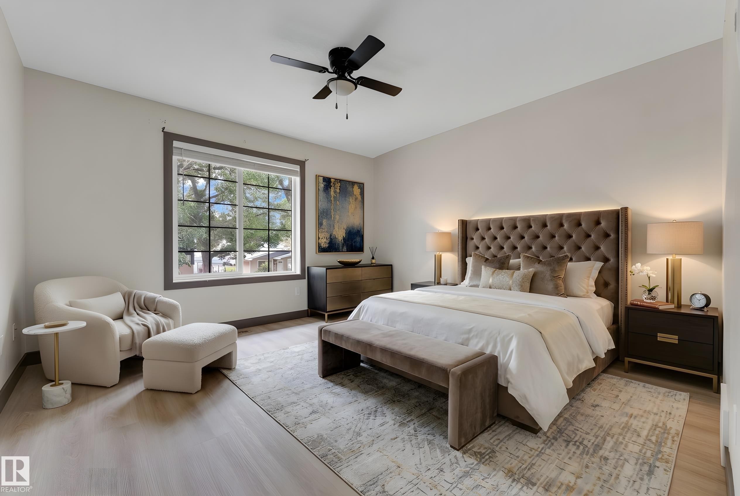 Spacious bedroom featuring wood-finish flooring, a large window with exterior tree views, a ceiling fan, and ample wall space - 11817 37 Street Nw, Edmonton, AB - Indoor Photo Showing Bedroom