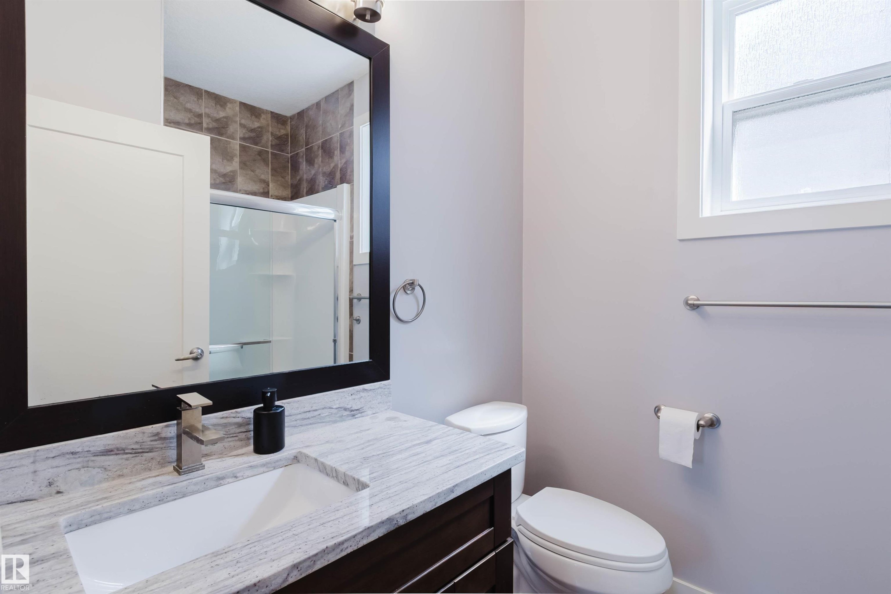 Bathroom vanity with a rectangular undermount sink, stone countertop, and dark wood-finish cabinetry - 10626 81 Avenue Nw, Edmonton, AB - Indoor Photo Showing Bathroom