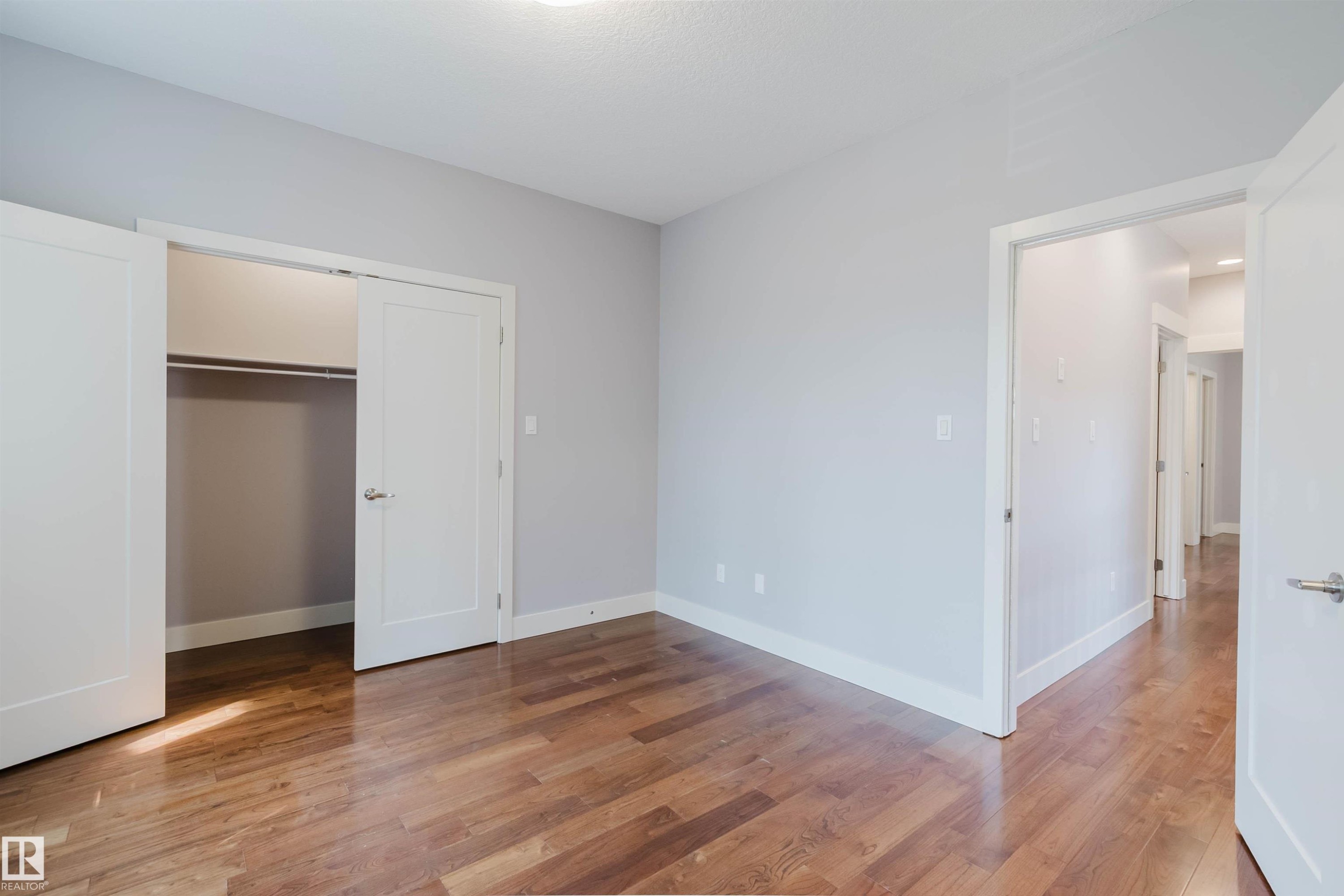 Spacious room featuring wood-finish flooring, light grey walls, and a recessed ceiling light - 10626 81 Avenue Nw, Edmonton, AB - Indoor Photo Showing Other Room