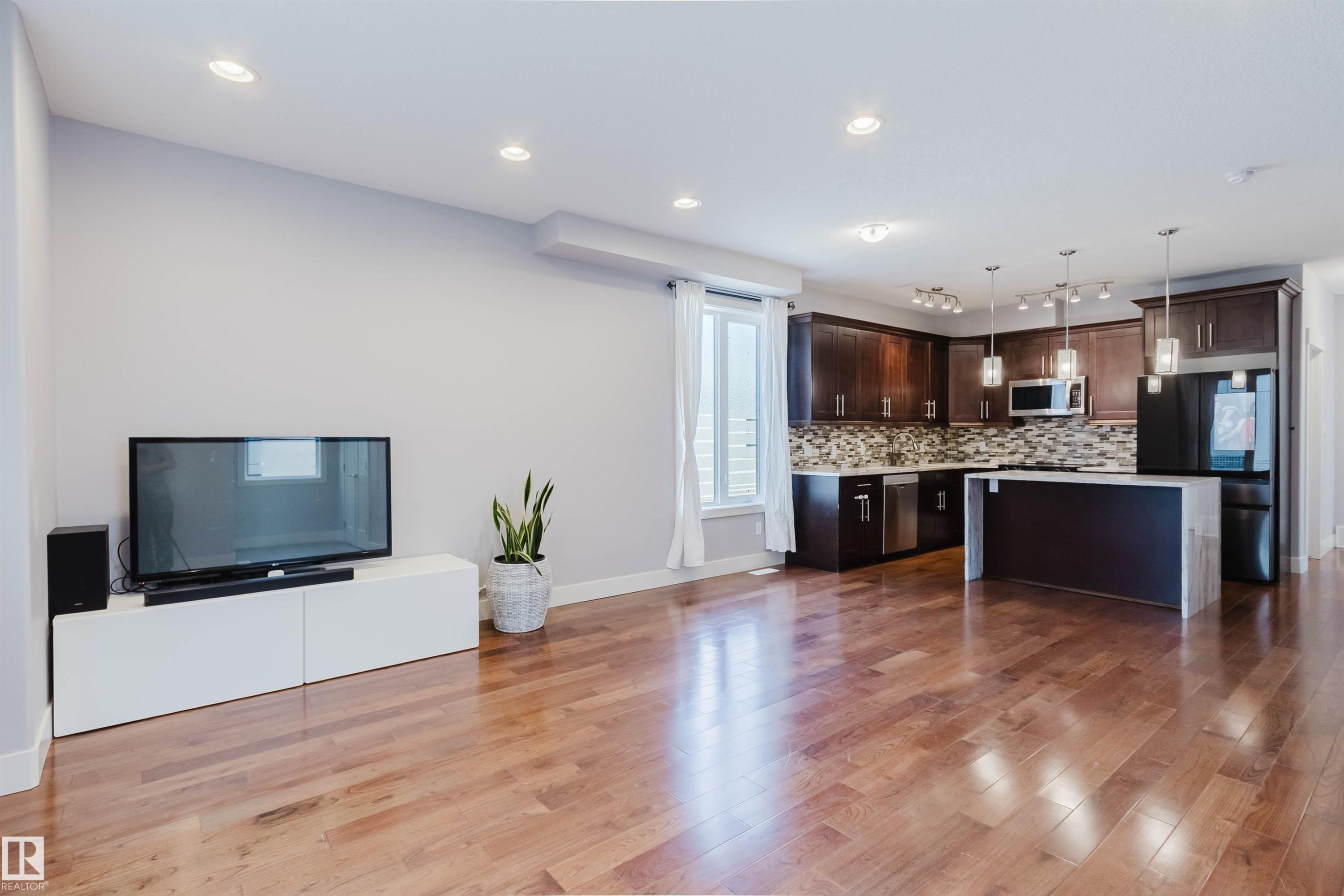 Open-concept living area featuring rich wood-finish flooring throughout - 10626 81 Avenue Nw, Edmonton, AB - Indoor Photo Showing Kitchen With Upgraded Kitchen