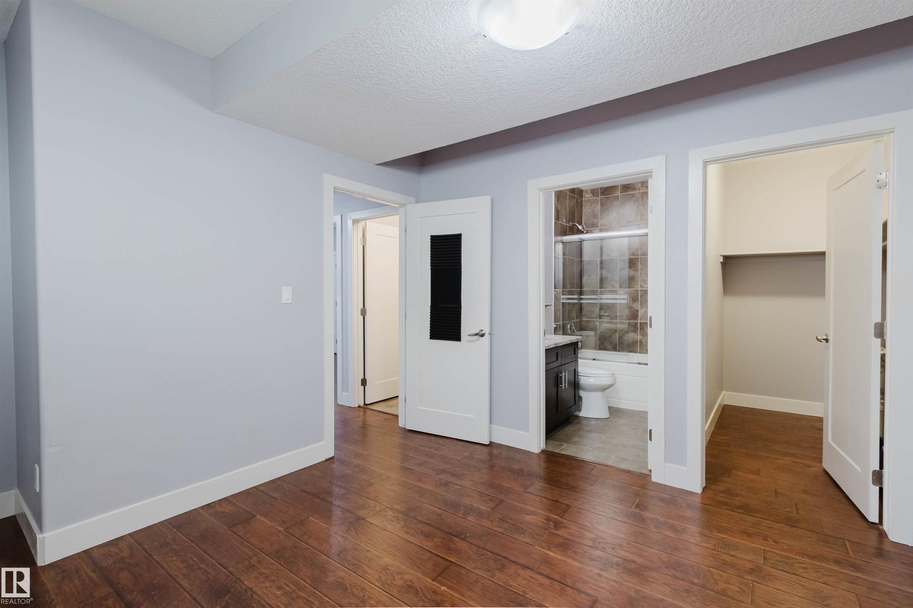 Hardwood flooring extending throughout, complemented by light gray walls and white trim - 10626 81 Avenue Nw, Edmonton, AB - Indoor Photo Showing Other Room