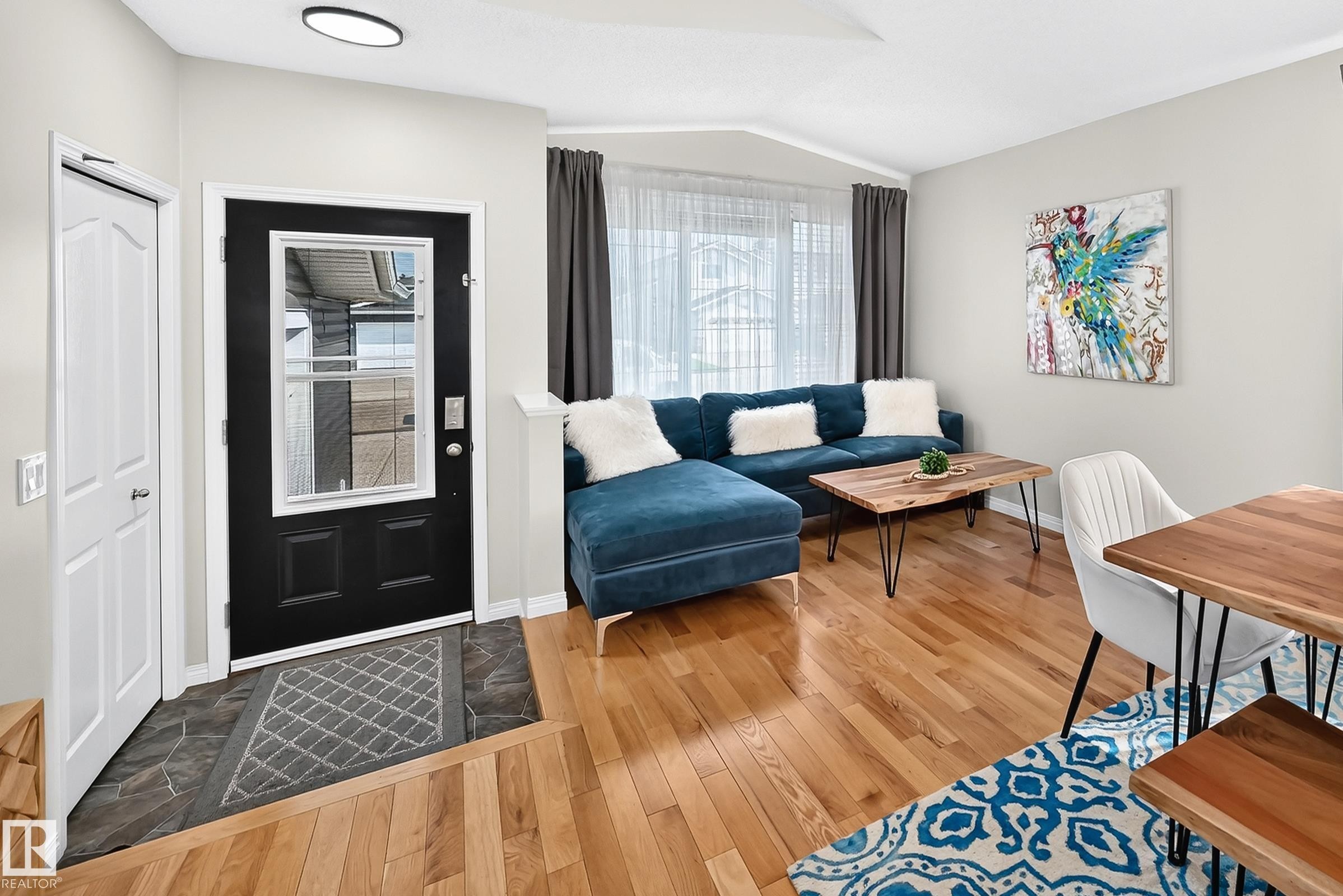 Entryway featuring a black front door with a glass insert, stone tile flooring, and a hall closet with a white panel door - 3729 131A Avenue Nw, Edmonton, AB - Indoor