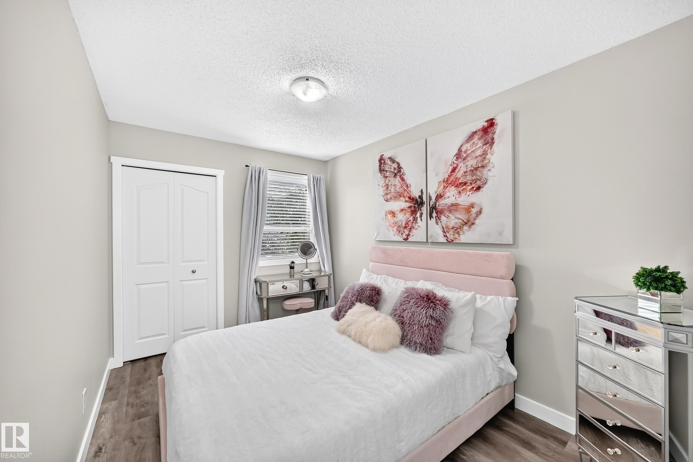 Bedroom featuring wood-finish flooring, light grey painted walls, a window with horizontal blinds, and a bi-fold closet door - 3729 131A Avenue Nw, Edmonton, AB - Indoor Photo Showing Bedroom