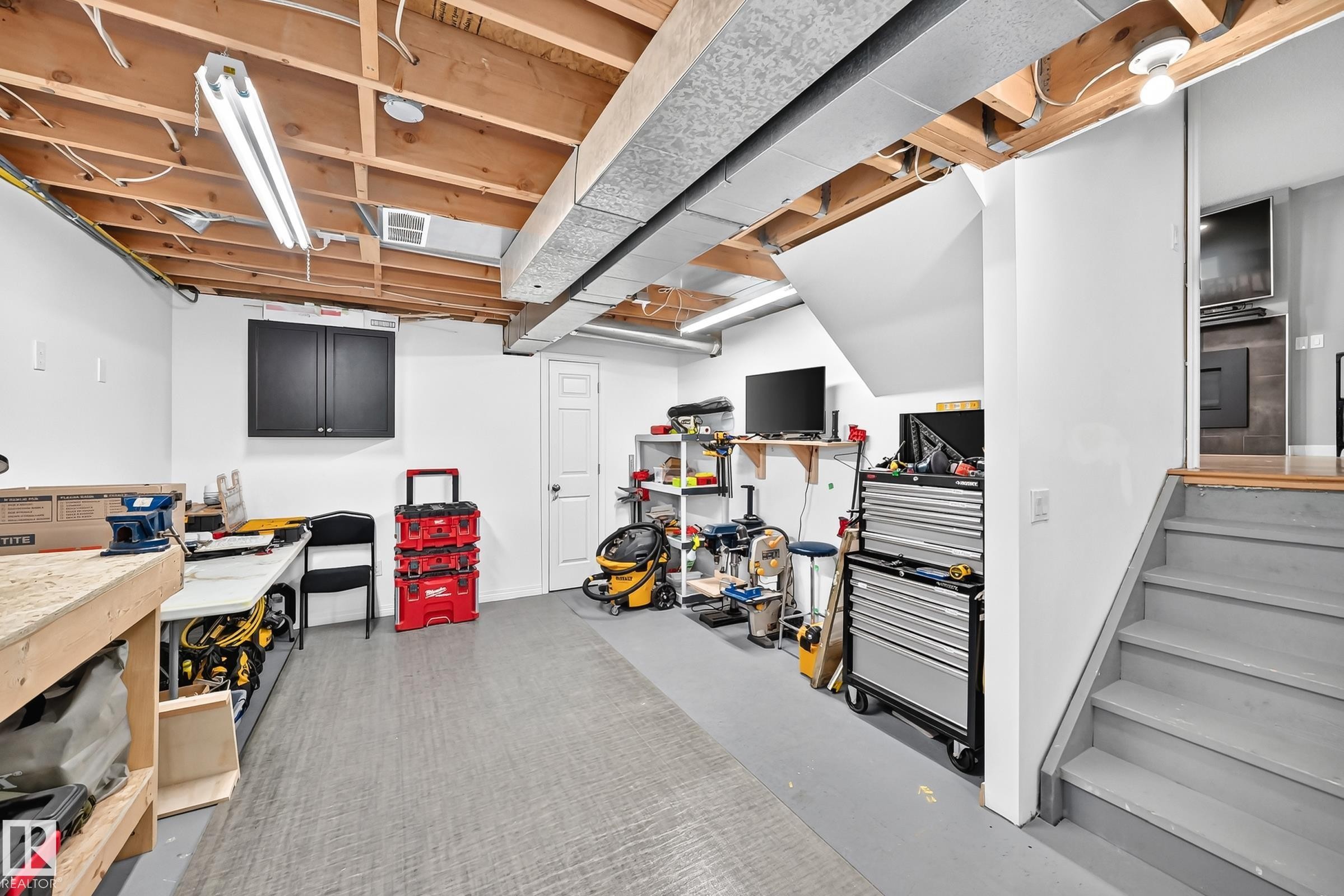 Finished basement space featuring exposed ceiling joists, overhead fluorescent lighting, and a neutral-toned floor - 3729 131A Avenue Nw, Edmonton, AB - Indoor Photo Showing Basement