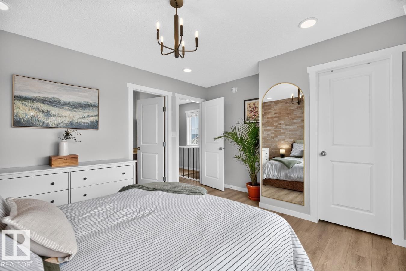Primary Bedroom Featuring South Facing Windows, Walk in Closet, Ensuite Bathroom, and Decorative Wall Paper. - 1051 Cy Becker Road Nw, Edmonton, AB - Indoor Photo Showing Bedroom