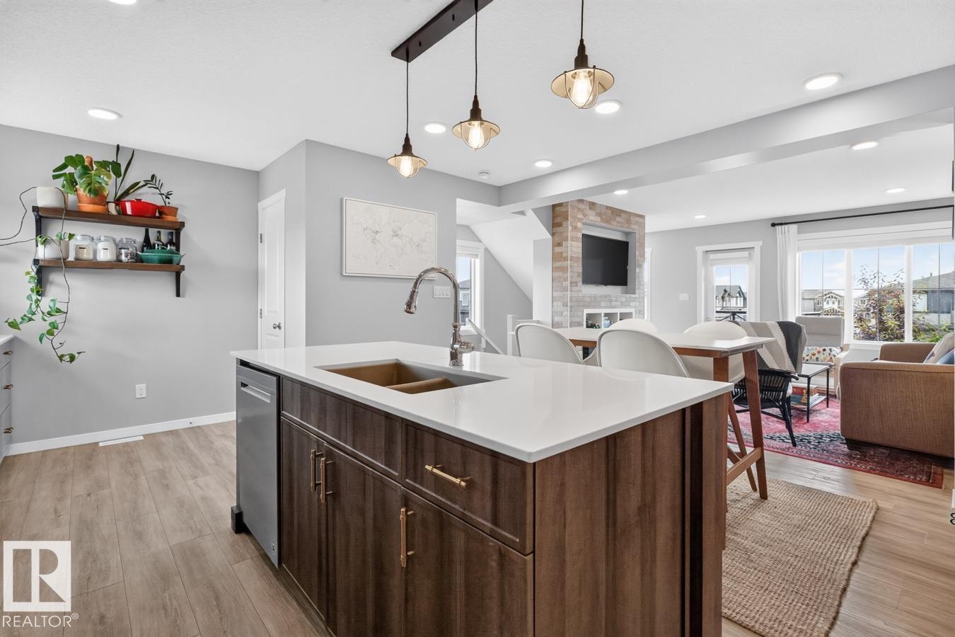 Open Concept Kitchen featuring Stainless Steel Appliances, Stylish Lighting and Accent Tiles, Bar Fridge, and Bar/Counter Seating. - 1051 Cy Becker Road Nw, Edmonton, AB - Indoor