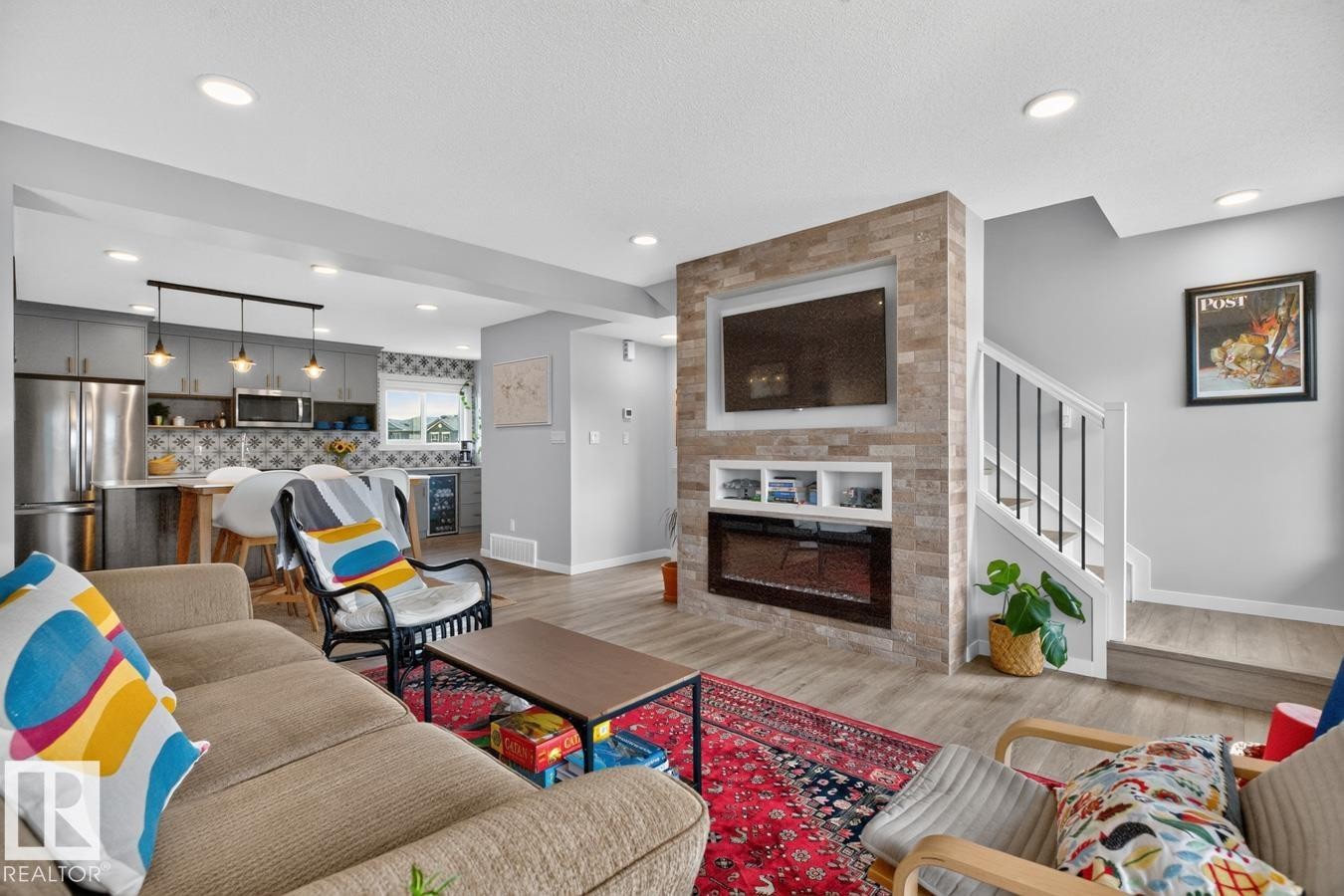Open Concept Living Room Space featuring Large South Facing Window, Access to Balcony, Electric Fireplace, and Ample Space for Gatherings. - 1051 Cy Becker Road Nw, Edmonton, AB - Indoor Photo Showing Living Room