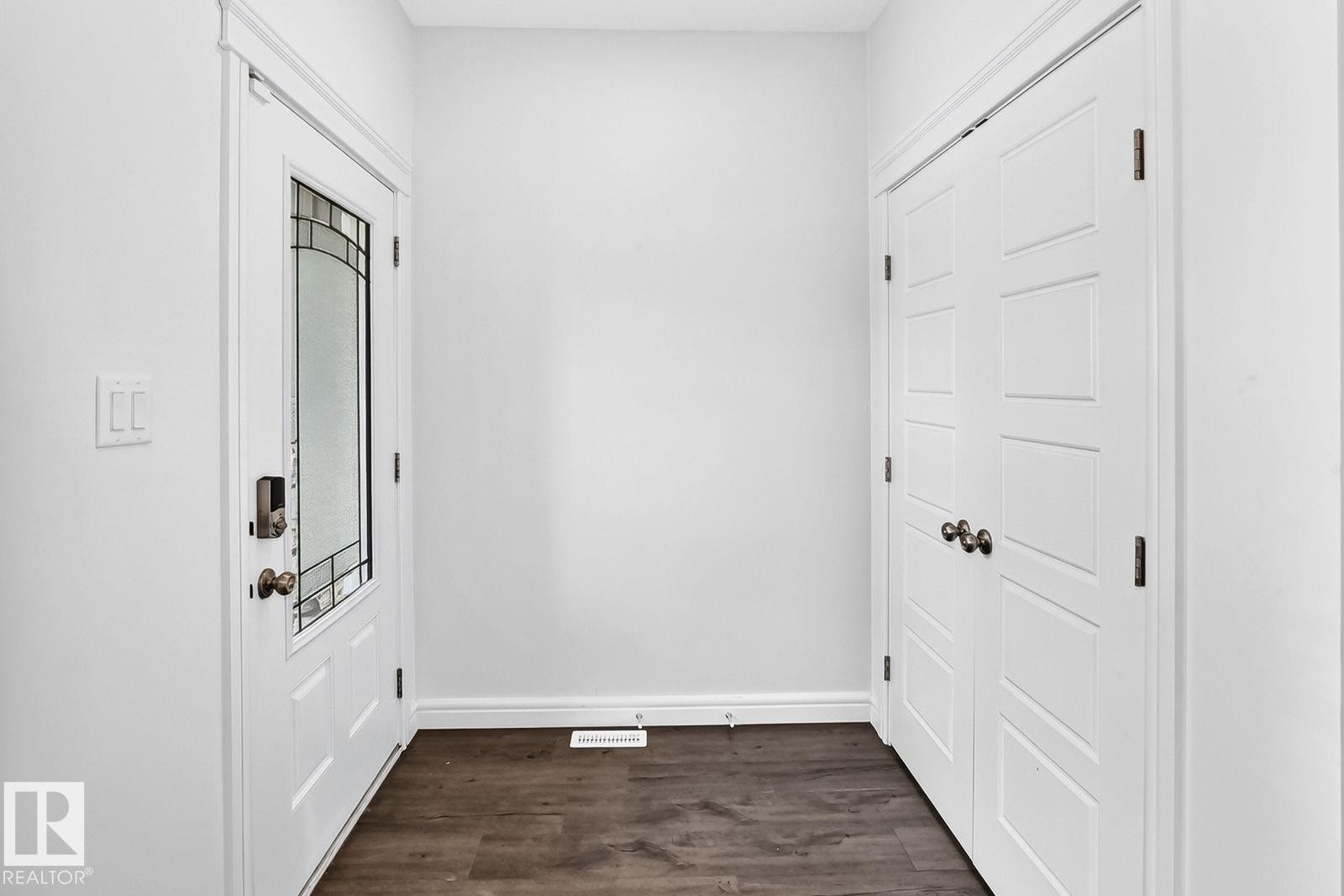Entryway featuring a white paneled door with decorative glass insert and dark hardware - 1261 Rosenthal Boulevard Nw, Edmonton, AB - Indoor Photo Showing Other Room
