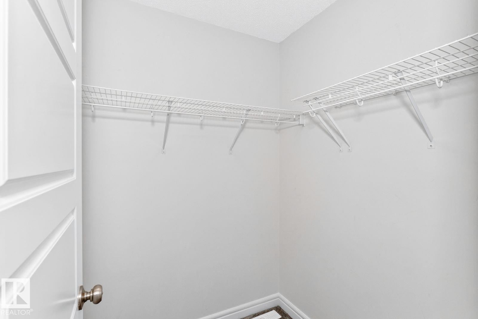 Walk-in closet featuring wire shelving, white painted walls, and textured ceiling - 1261 Rosenthal Boulevard Nw, Edmonton, AB - Indoor With Storage