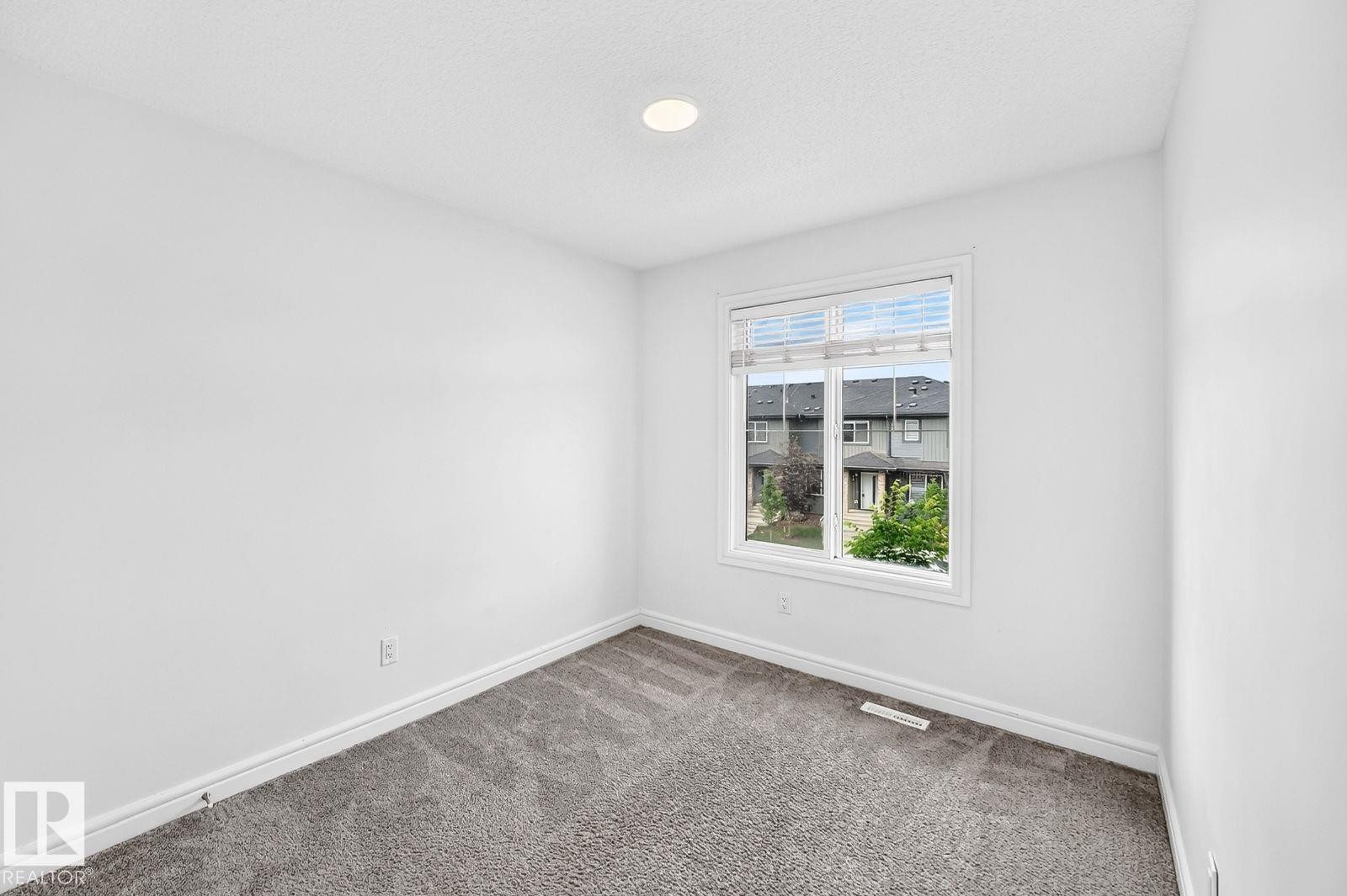 Room featuring neutral carpet, white walls, white baseboards, a single window, and a recessed ceiling light - 1261 Rosenthal Boulevard Nw, Edmonton, AB - Indoor Photo Showing Other Room