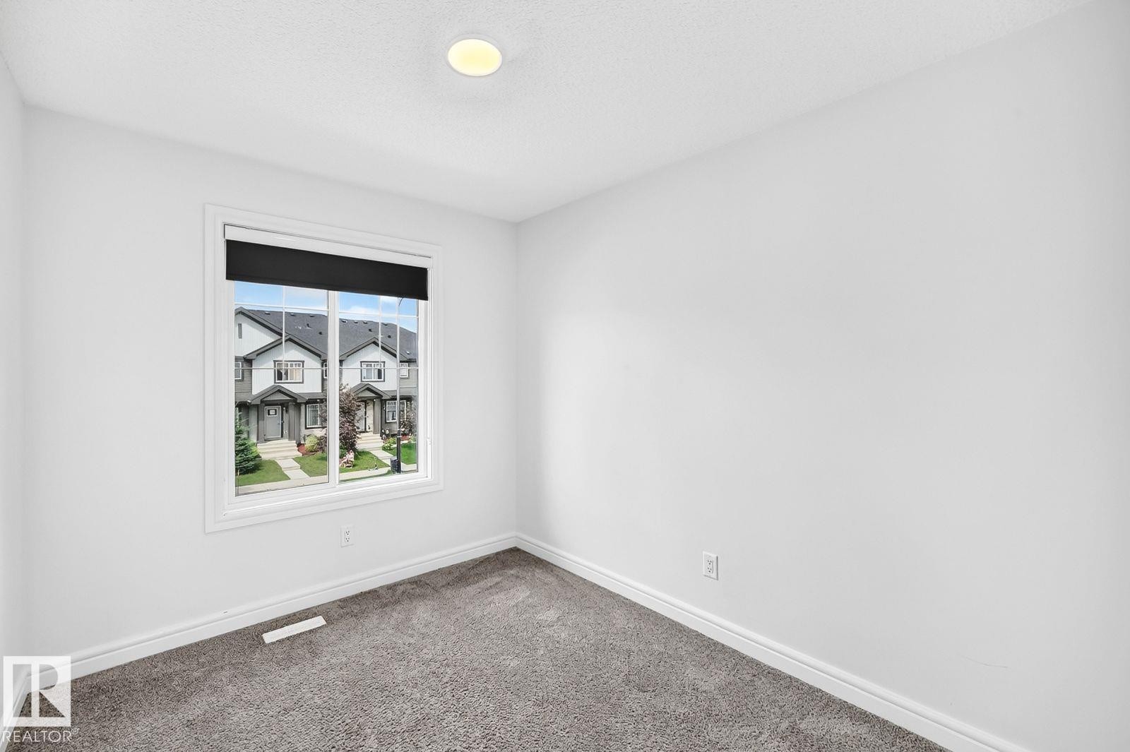 Room featuring neutral wall finishes, grey textured carpeting, and white baseboards - 1261 Rosenthal Boulevard Nw, Edmonton, AB - Indoor Photo Showing Other Room