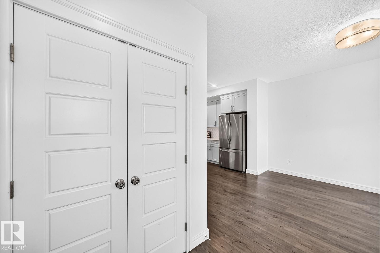 Entryway with panel-style closet doors and dark wood-finish flooring - 1261 Rosenthal Boulevard Nw, Edmonton, AB - Indoor Photo Showing Other Room