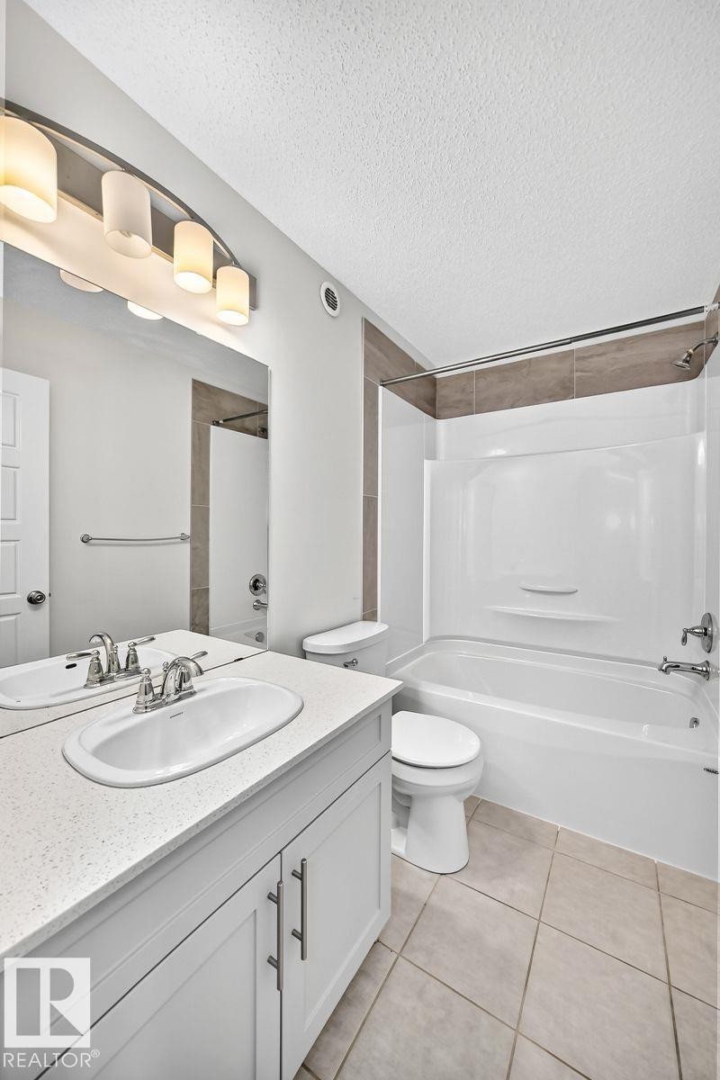 Bathroom featuring a white vanity with a light-toned countertop, a built-in oval sink, and chrome fixtures - 1261 Rosenthal Boulevard Nw, Edmonton, AB - Indoor Photo Showing Bathroom