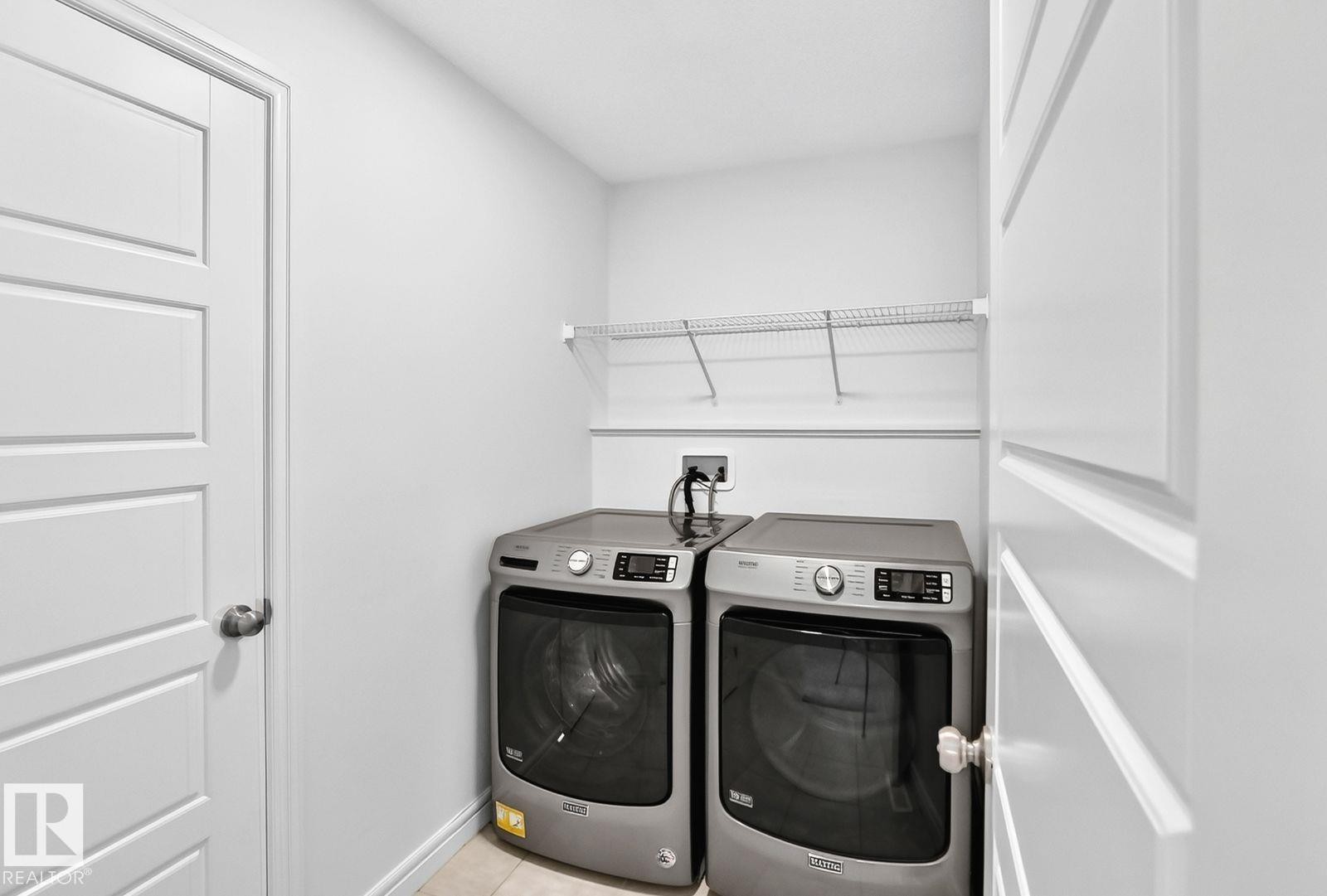 Dedicated utility space featuring a wire shelving unit, light-toned wall paint, and neutral floor tiling - 1261 Rosenthal Boulevard Nw, Edmonton, AB - Indoor Photo Showing Laundry Room