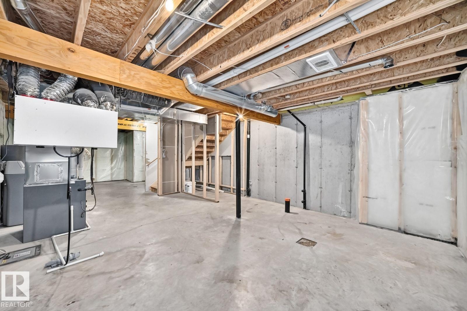 Unfinished basement featuring exposed wood joists and concrete flooring - 1261 Rosenthal Boulevard Nw, Edmonton, AB - Indoor Photo Showing Basement
