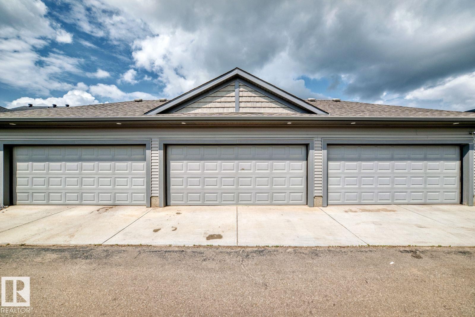 Three-stall garage with panel-style doors and concrete driveways - 1261 Rosenthal Boulevard Nw, Edmonton, AB - Outdoor
