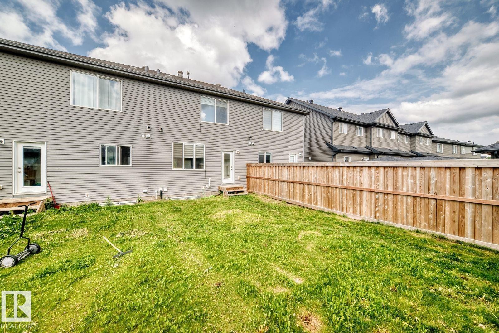 Spacious backyard with a horizontal wooden privacy fence - 1261 Rosenthal Boulevard Nw, Edmonton, AB - Outdoor With Exterior