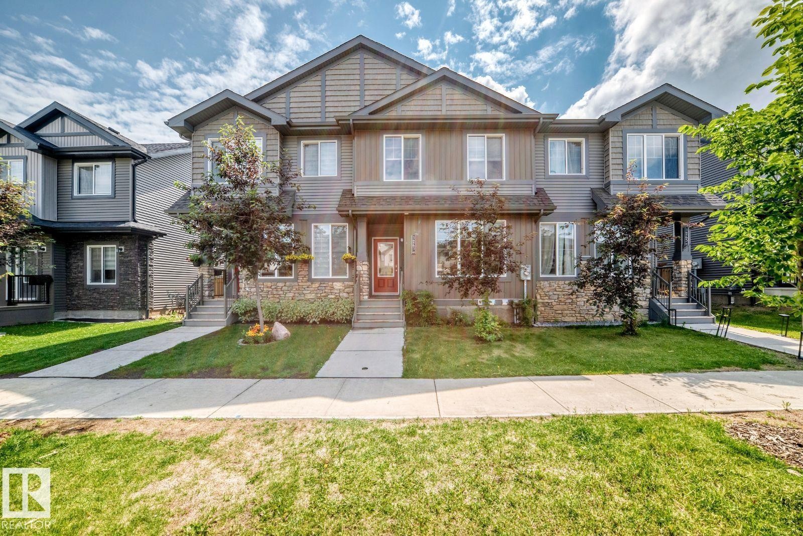 Three-story townhome with a mixed material exterior featuring stone detailing, horizontal siding, and shake siding - 1261 Rosenthal Boulevard Nw, Edmonton, AB - Outdoor With Facade